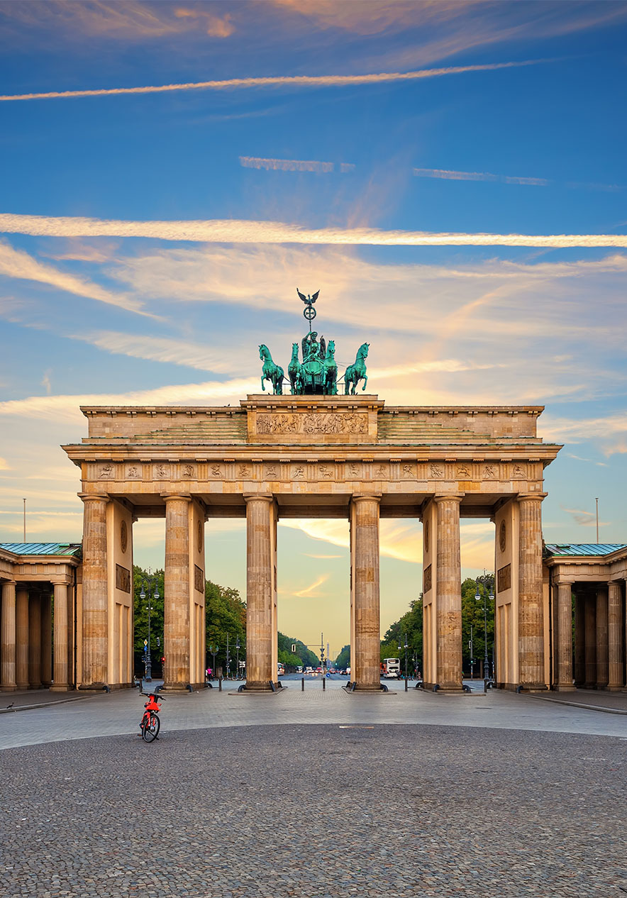 Blick auf das Brandenburger Tor in Berlin an einem klaren Tag mit wenigen Wolken und einem Fahrrad auf dem Gehweg