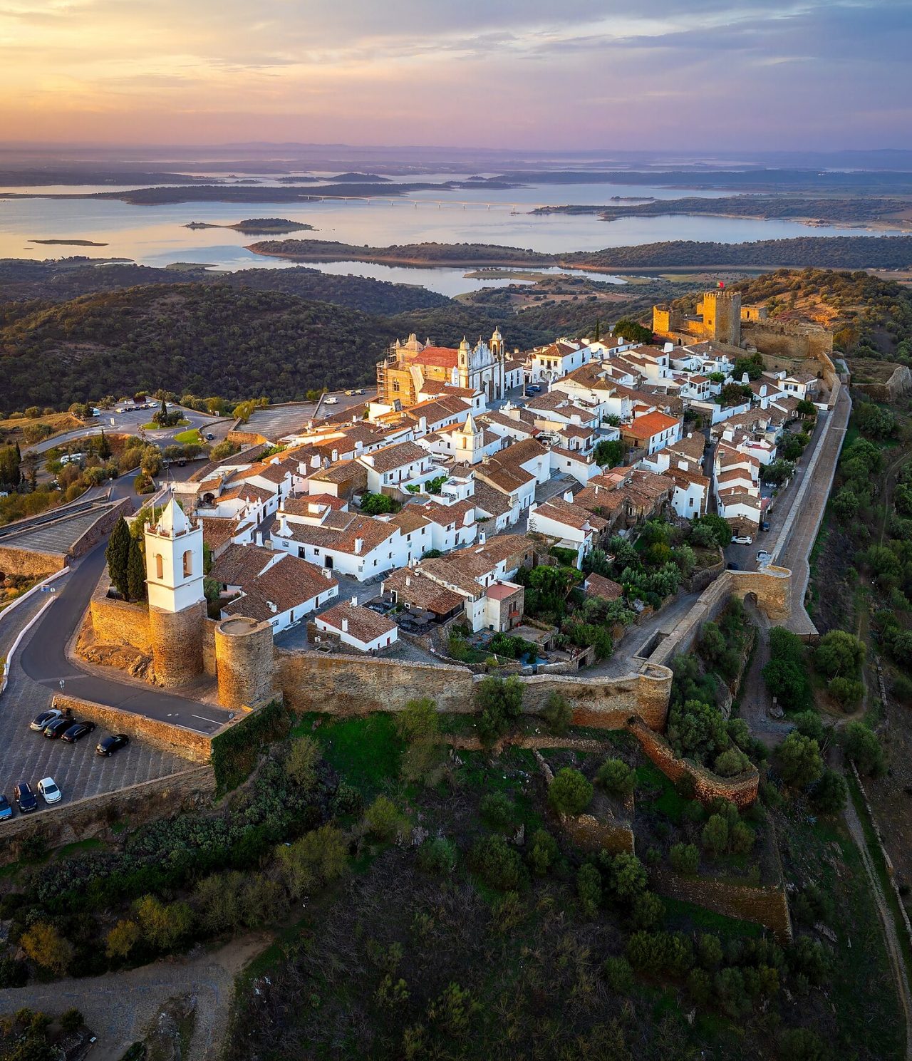 Luftaufnahme des Hügels von Monsaraz in Alentejo bei Sonnenuntergang, mit einem Schloss, einer Kathedrale und dem Dorf