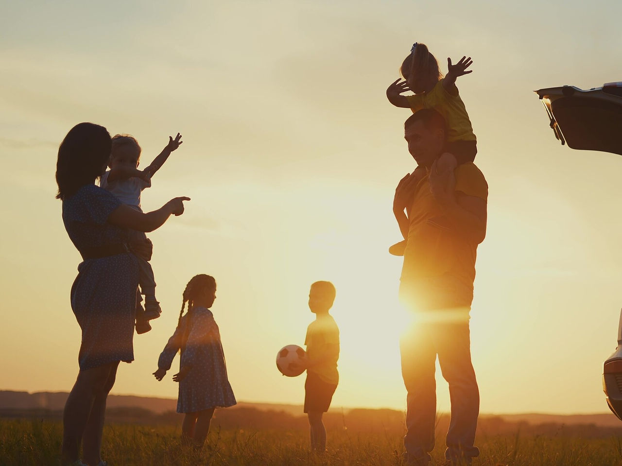 Familie von sechs Personen unterhält sich während einer Pause auf ihrer Autoreise in der Algarve-Region