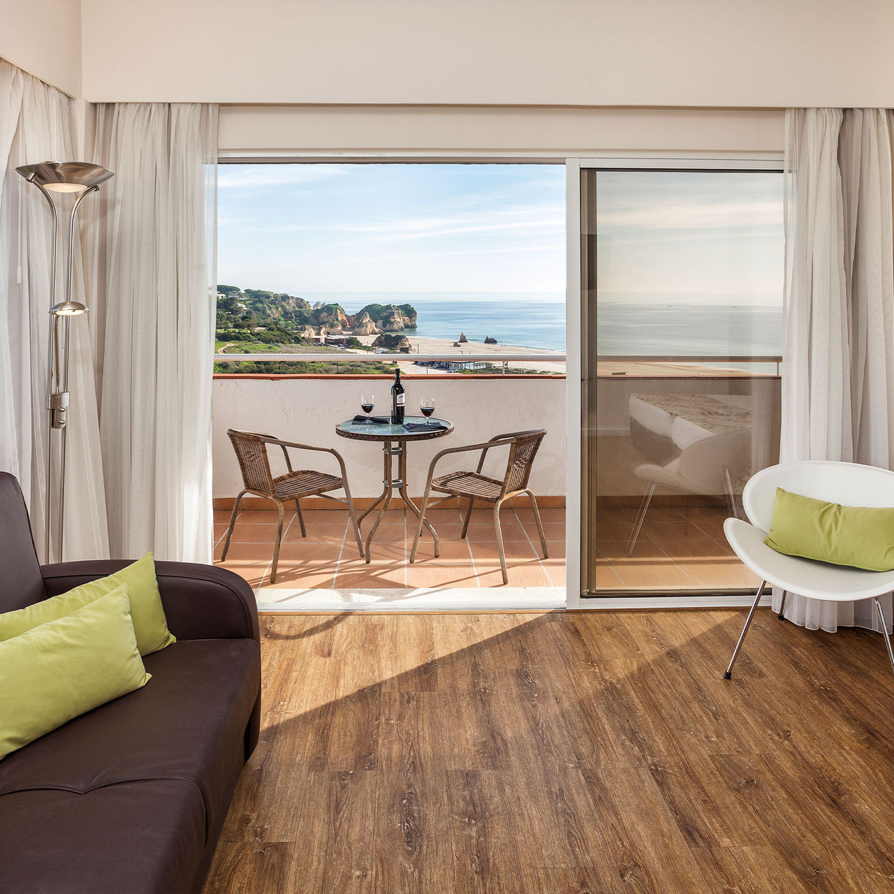 Blick auf ein Apartment im Pestana Alvor Atlântico, mit Balkon und Meerblick, zwei Weingläsern