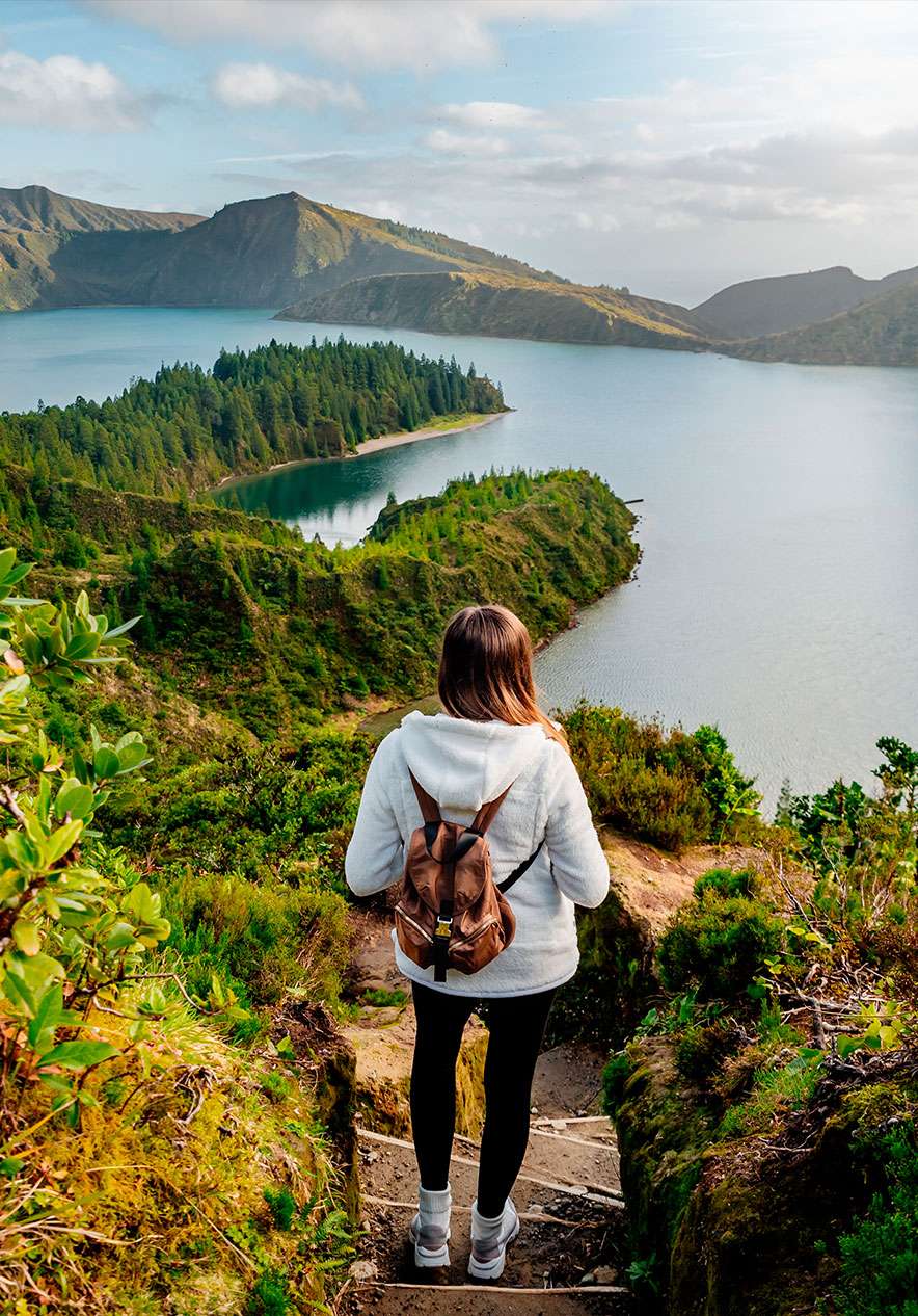 Mädchen mit Rucksack, geht die Treppen zur herrlichen Lagoa do Fogo hinauf, umgeben von Natur