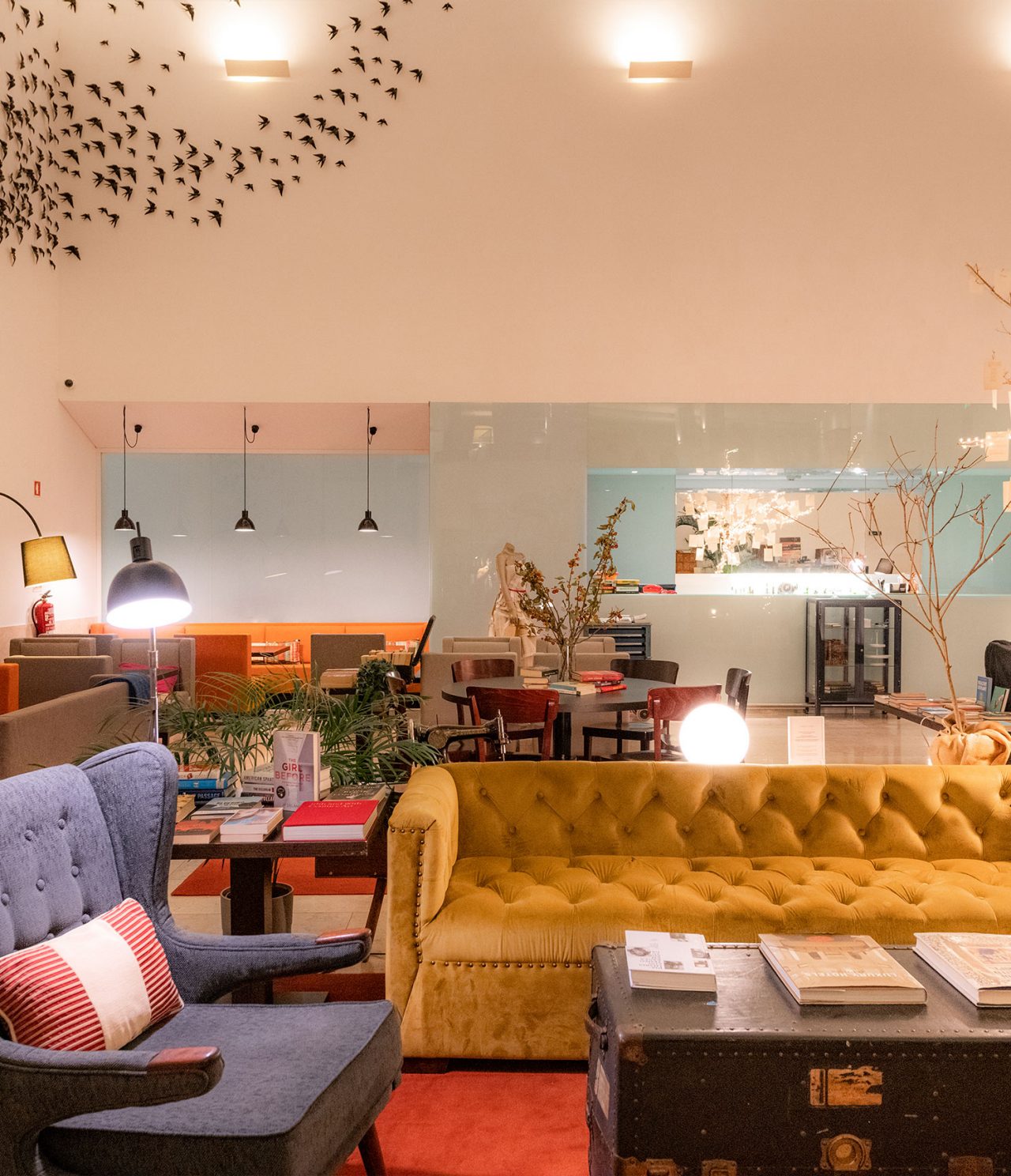 Die Bar The Chapter im 5-Sterne-Hotel in Cascais hat ein gelbes Sofa, einen grauen Sessel und einen Tisch