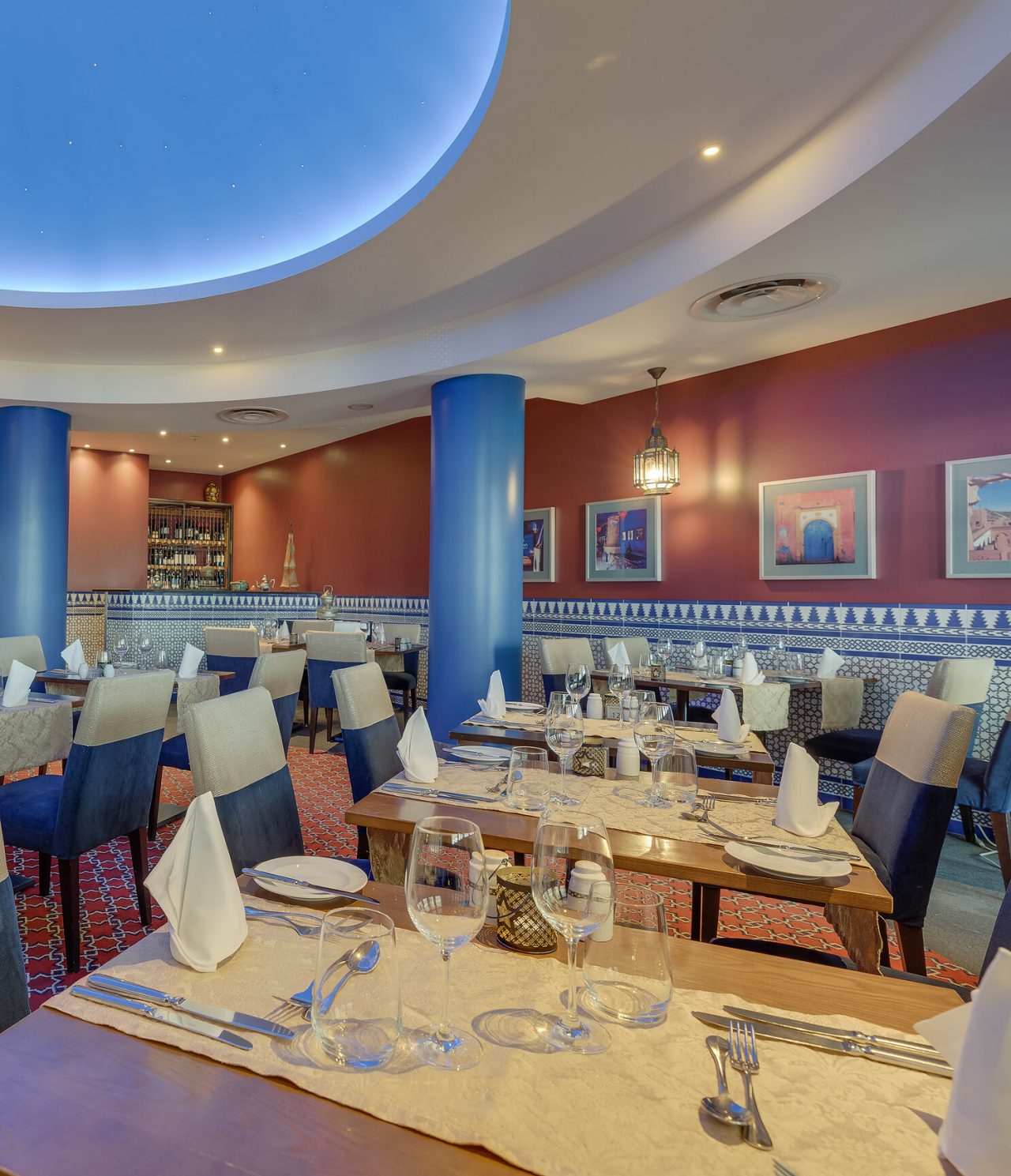 Das Restaurant Au Tagine im 5-Sterne-Hotel in Funchal, Madeira, hat einen großen Raum mit Bildern und Tischen mit Stühlen