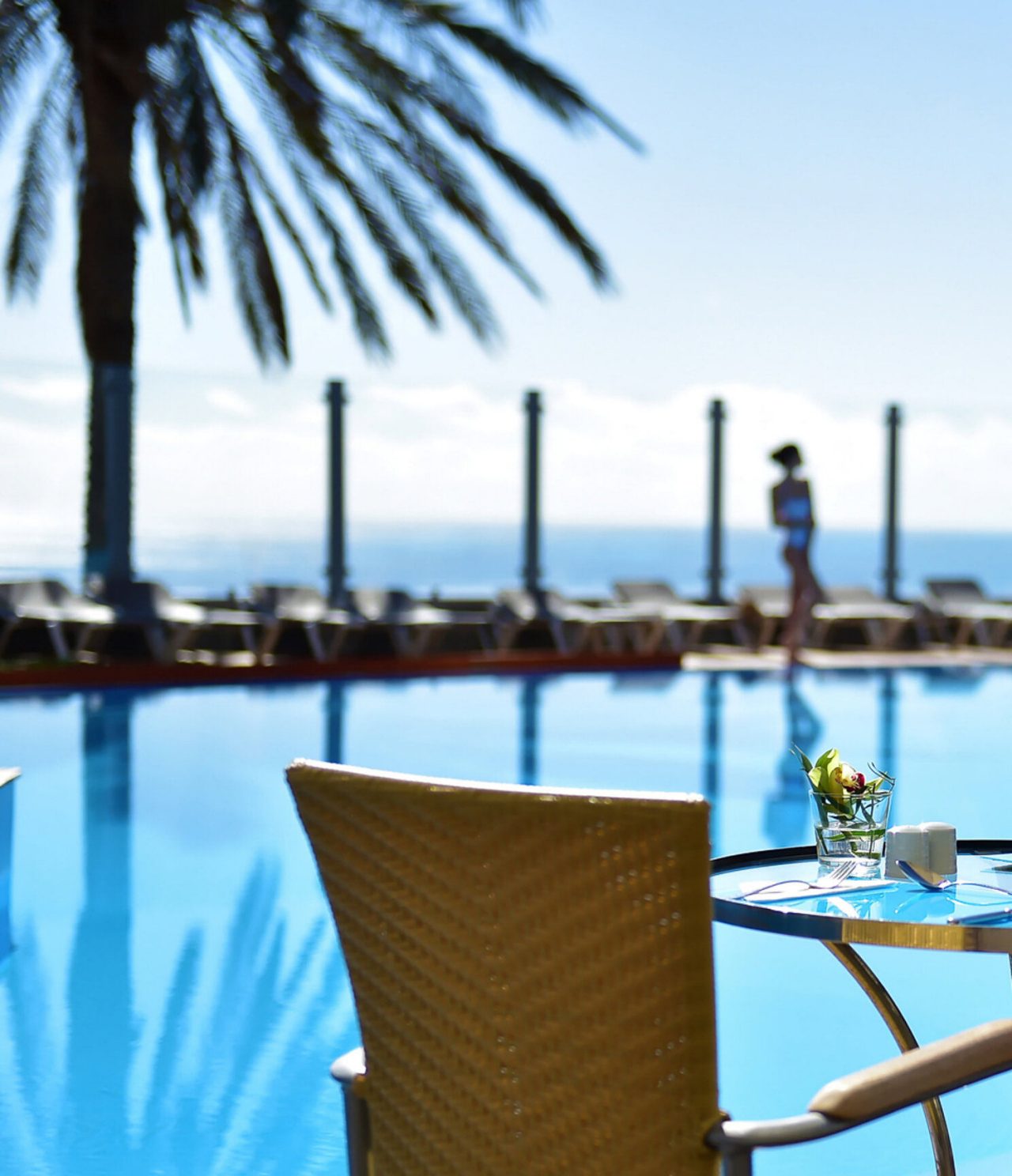 Die Poolbar im 5-Sterne-Hotel in Funchal, Madeira, hat eine Außenterrasse mit Blick auf den Pool und Tischen mit Stühlen
