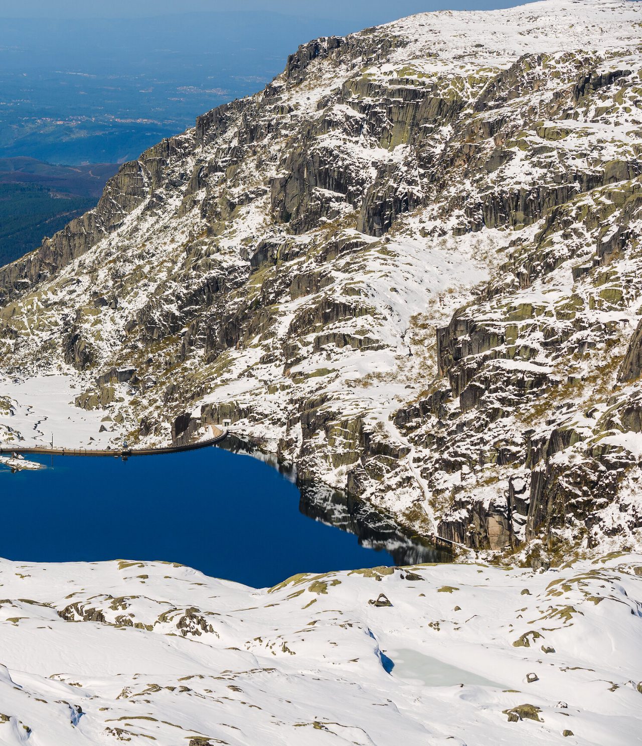 Die unberührte Schönheit der Berglandschaft, der türkisfarbene See im Kontrast zum weißen Schnee