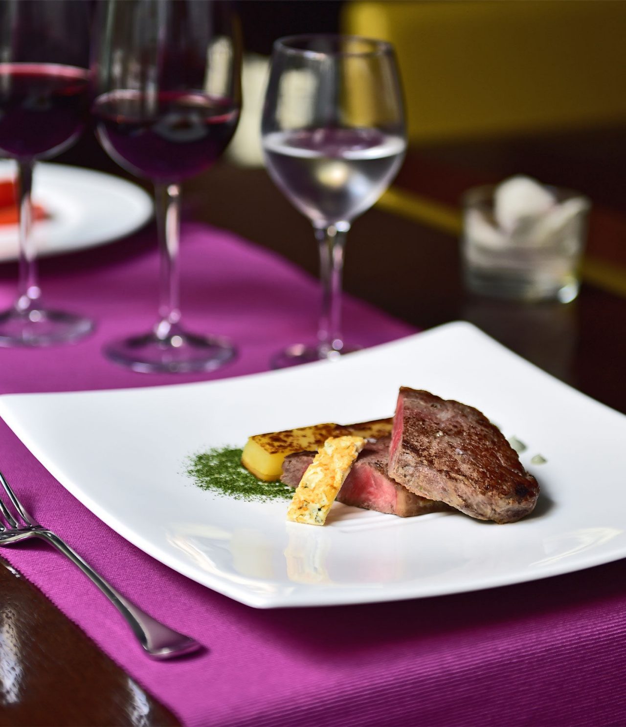 Die Bar Lobby im Hotel in Barcelona hat einen eleganten Teller mit Fleisch und Obst sowie ein Glas Wein und Wasser
