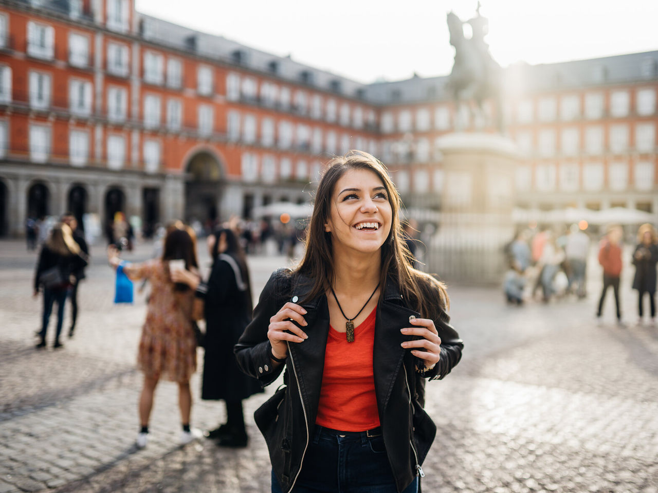 Glückliches Mädchen mit Rucksack schlendert durch die Plaza Mayor, im historischen Zentrum von Madrid