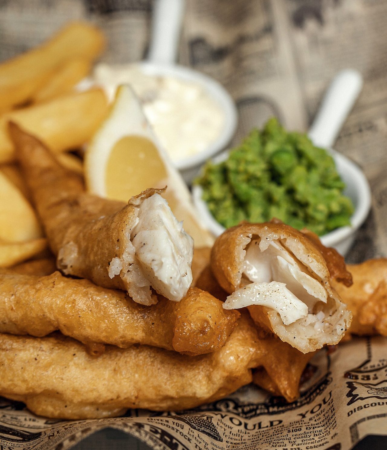 Frittierter Fisch mit Pommes, Zitrone, weißer Soße und grüner Paste, ein typisches Gericht von London
