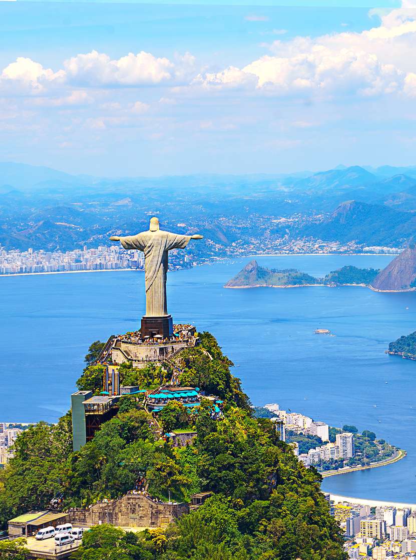 Ikonische Statue des Christus-Erlösers in Rio de Janeiro, mit der Stadt, dem Ozean und dem Strand im Hintergrund