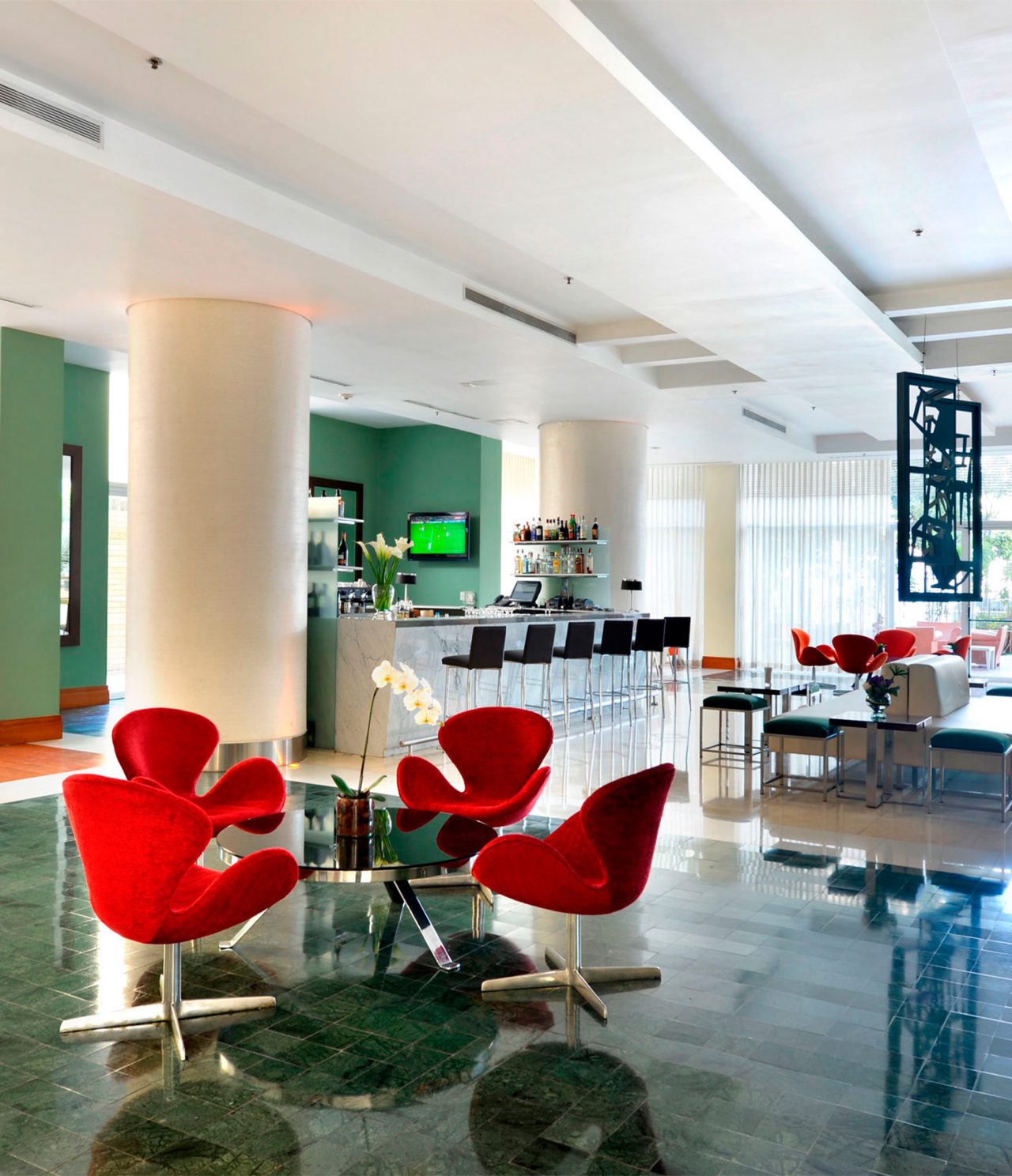 Die Lobby Bar im Hotel in Caracas hat viel Tageslicht, einen Fernseher und Tische für Getränke