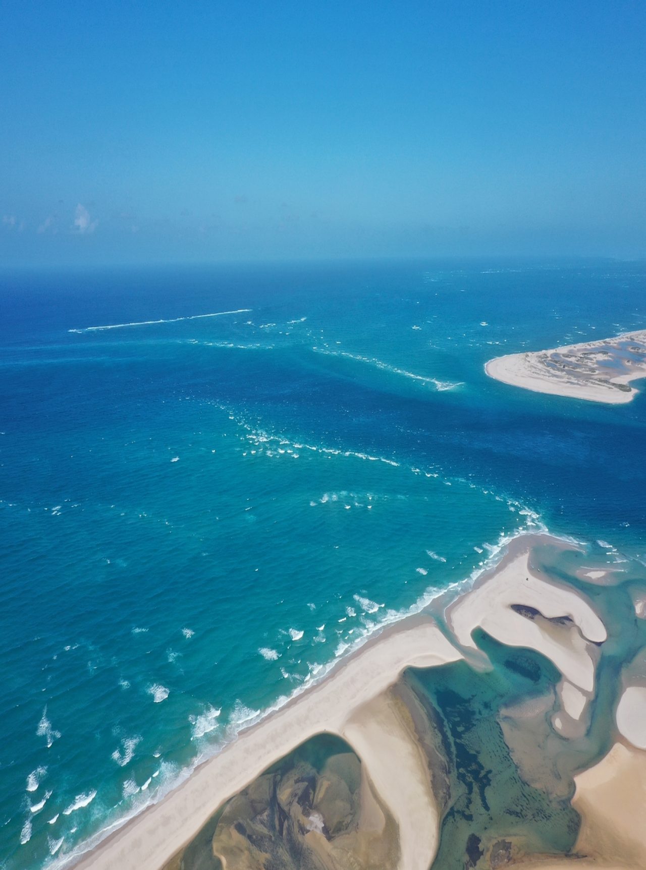 Stunning aerial view of Bazaruto Bay, with crystal-clear waters, white sand dunes, and coral reefs