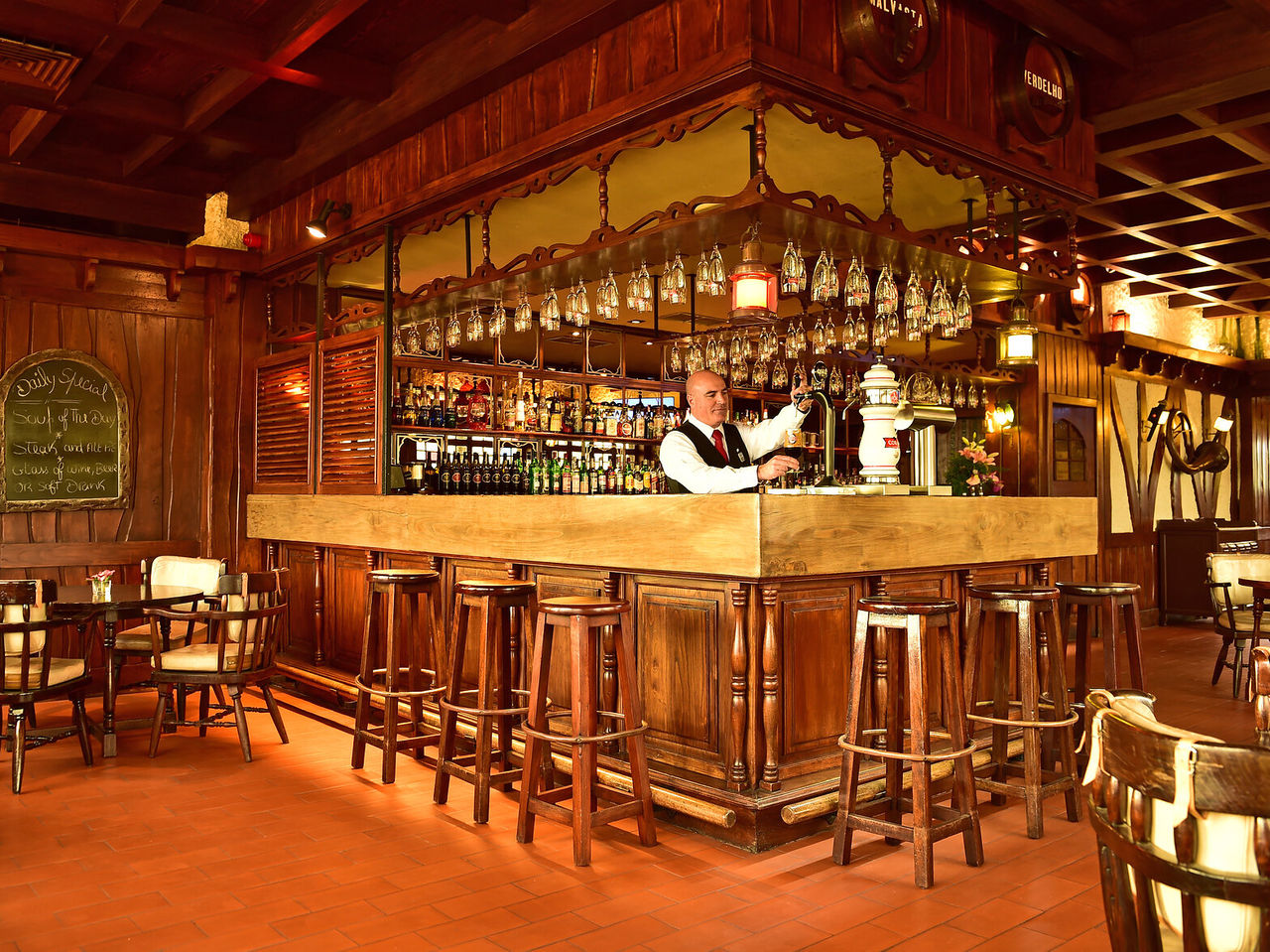 The Pub Funchal Central Hotel bar with high stools and various drinks