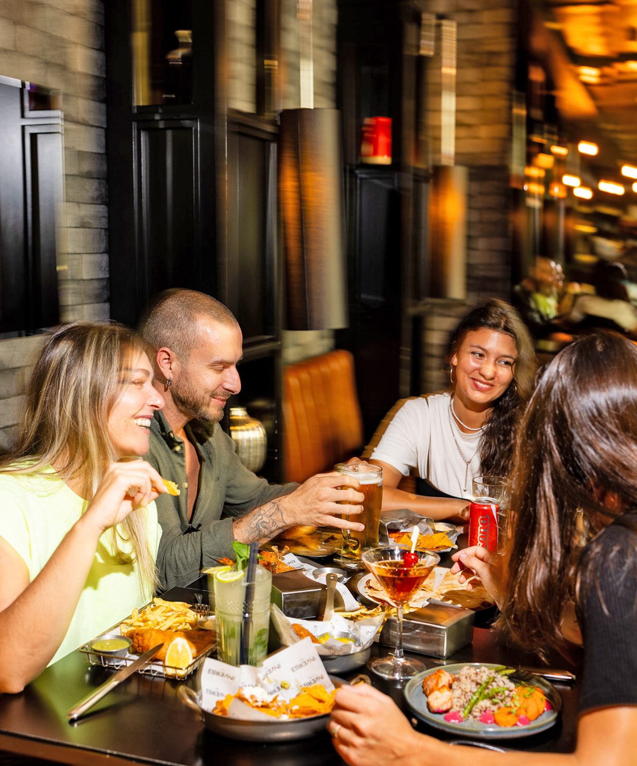 A group of friends enjoys the energy and relaxed atmosphere of the Inverse by CR7 sports bar that offers cocktails and dinner