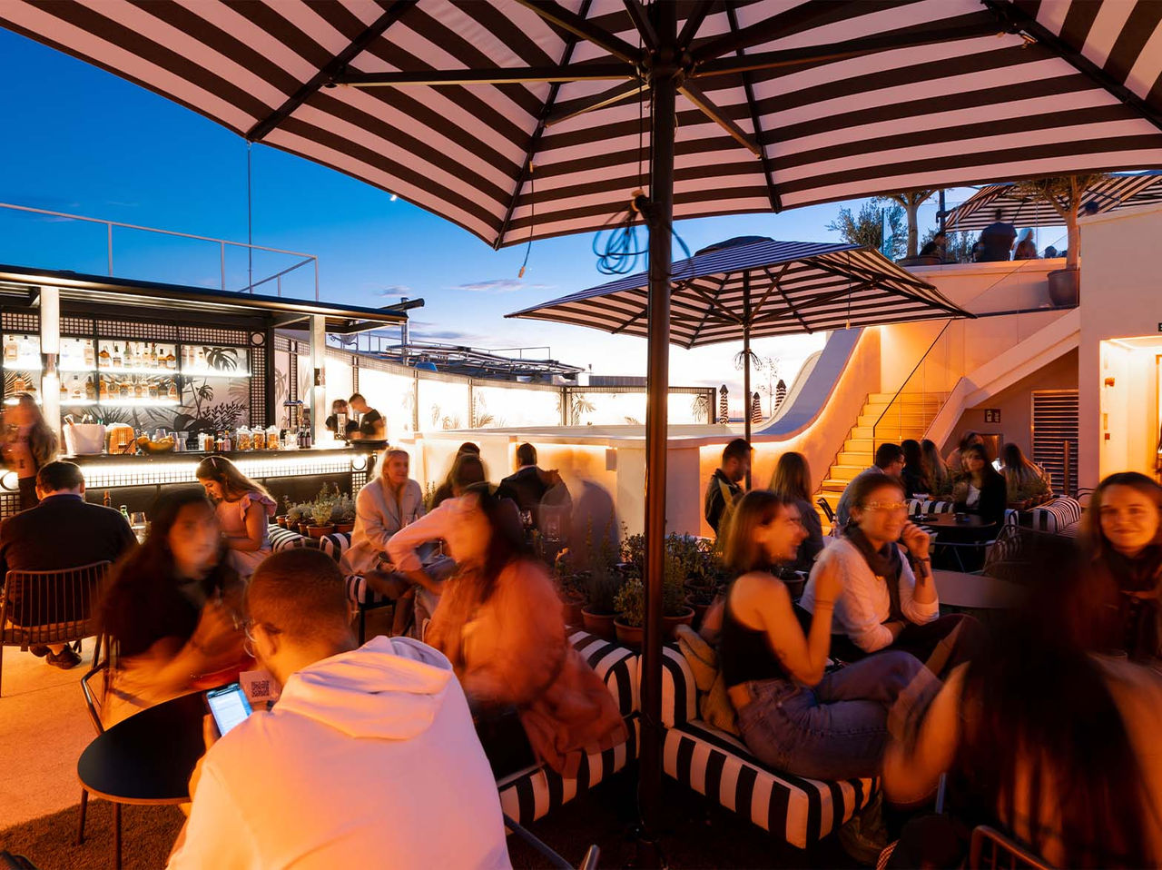El bar Rooftop Bar, del Hotel en el Centro de Madrid, España, tiene un amplio espacio con sombrillas, mesas y sofás