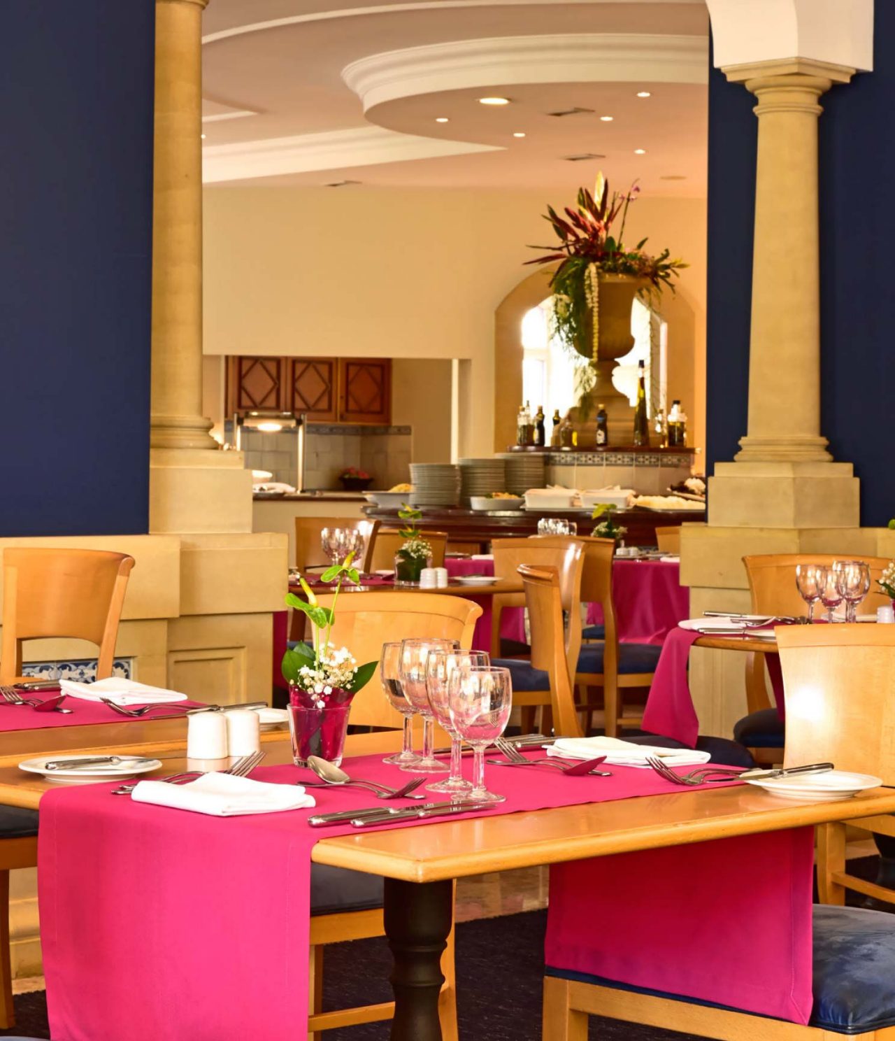 El restaurante A Vila, del Hotel de Charme en Madeira tiene varias mesas, con un mantel rojo y flores