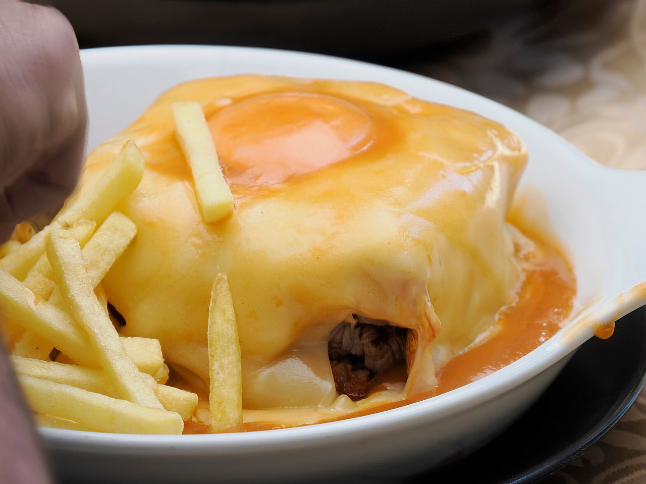 Francesinha típica de Oporto, famosa por su combinación de embutidos, pan, carne y salsa especial