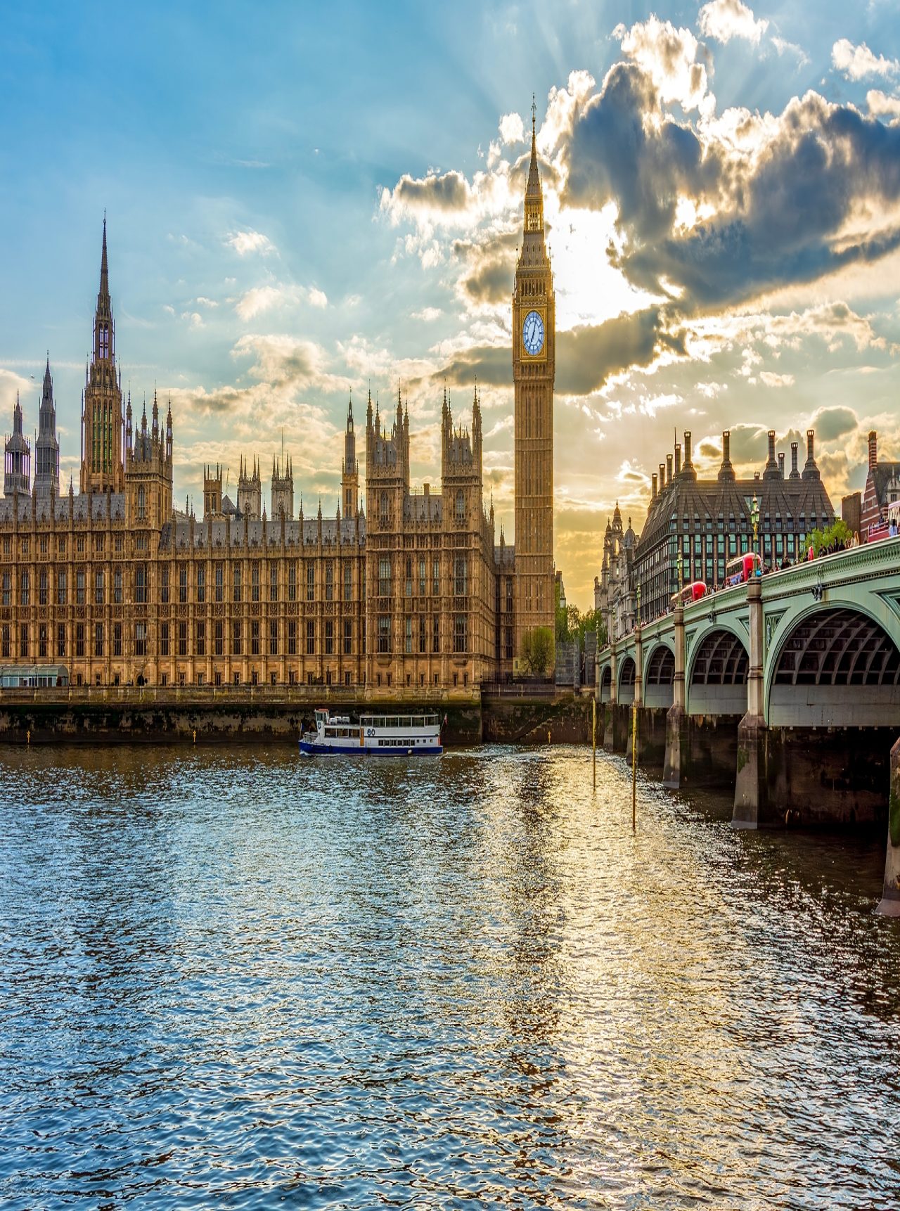Vista panorámica del Palacio de Westminster, en Londres, junto al emblemático Big Ben, con el río Támesis en primer plano.
