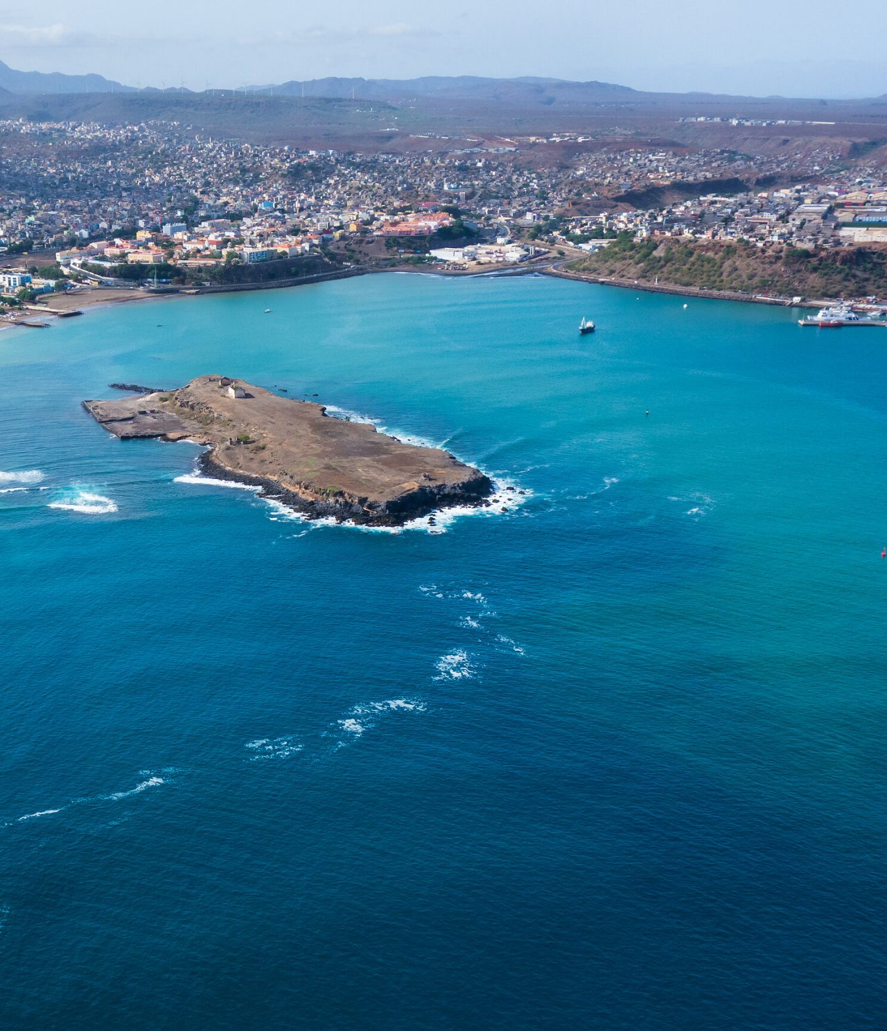 Vue aérienne de la ville de Praia contrastant avec l'océan bleu et le paysage urbain coloré