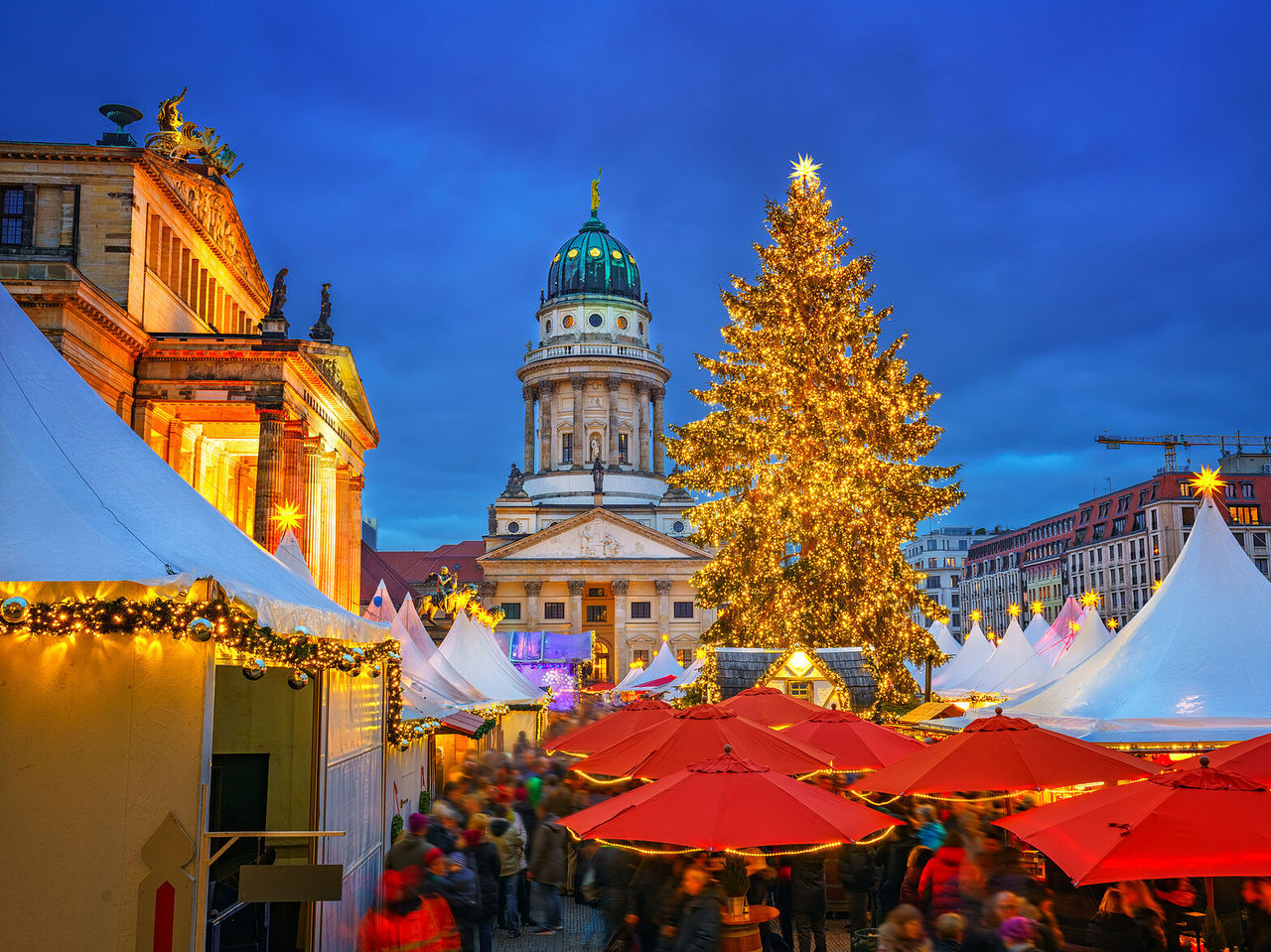Cathédrale Française de Berlin illuminée, avec un imposant arbre de Noël au centre d'un marché entouré de stands