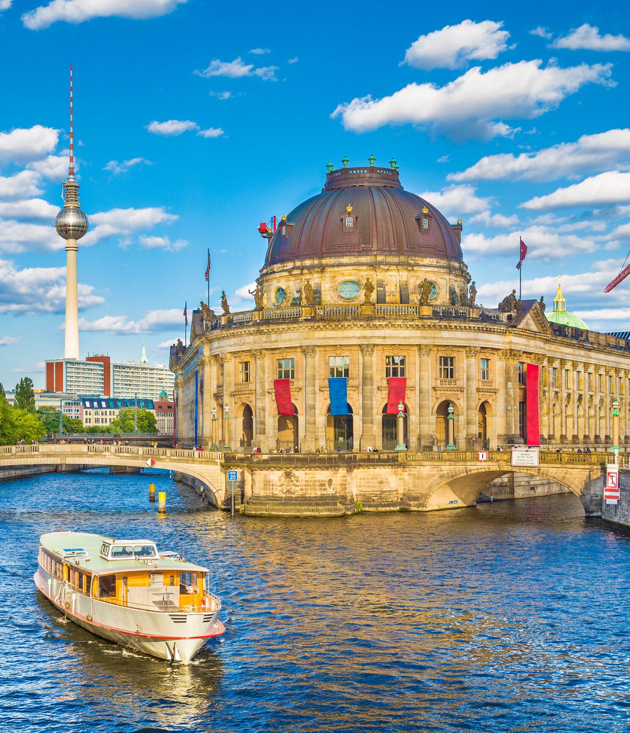 Ville de Berlin, avec un pont piétonnier sur un canal, un bateau, le musée Bode et la tour de télévision en arrière-plan