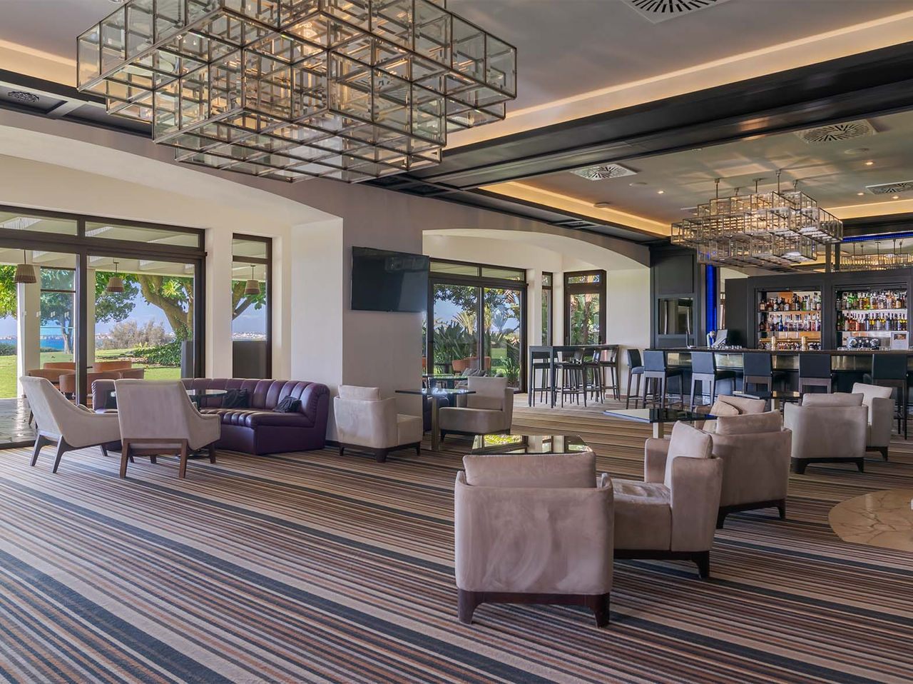 Le bar D Henrique de l’hôtel en Algarve a des canapés et fauteuils pour profiter des boissons et de la vue mer et jardin