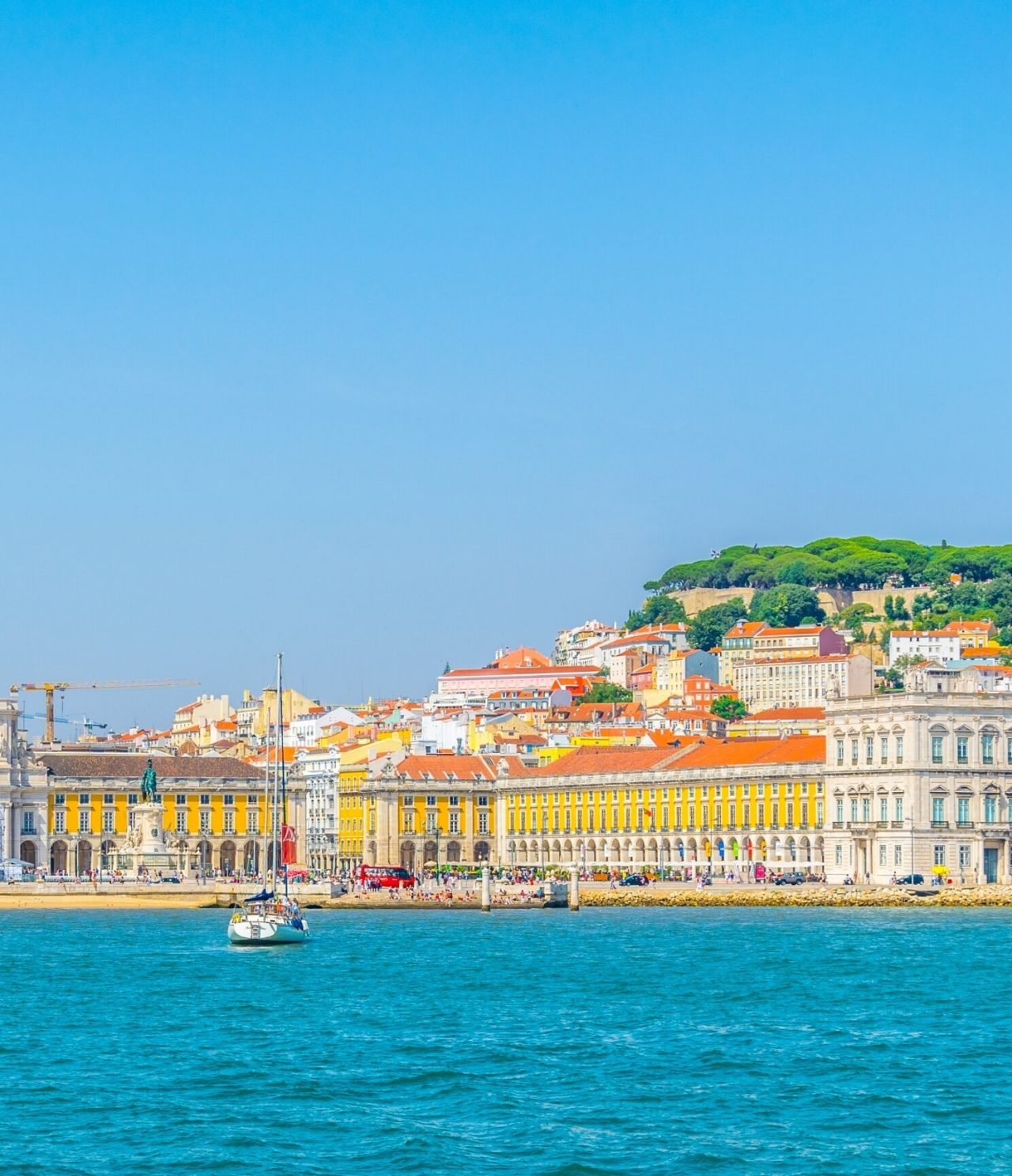 Vue sur la mer de Lisbonne, avec un bateau dans l'eau, Terreiro do Paço en arrière-plan et le centre-ville