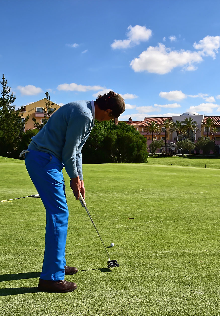 Dans un champ de golf, un homme s'apprête à frapper, concentré et dans une posture parfaite
