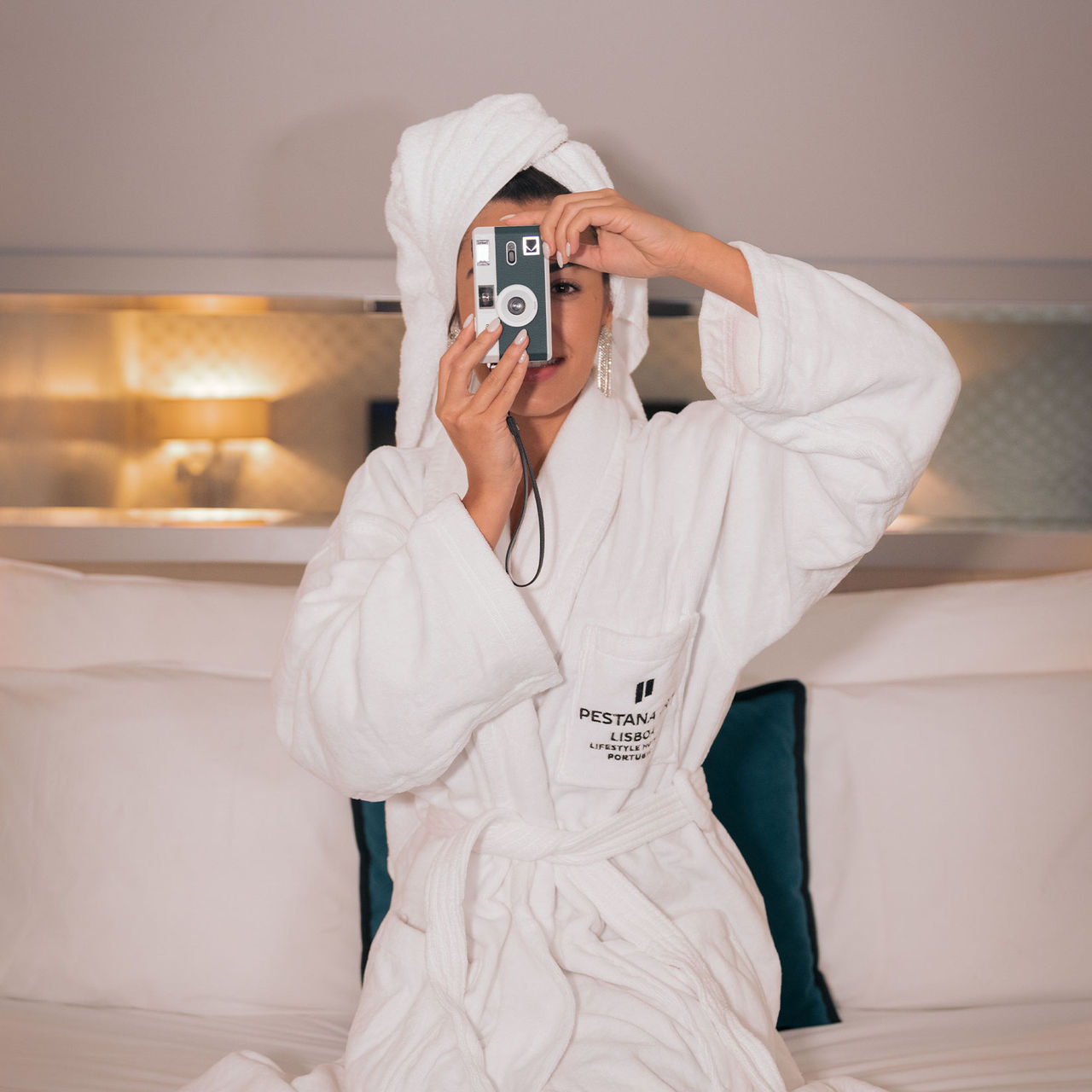 Fille prenant une photo avec un appareil numérique dans une chambre du Pestana CR7 Lisbonne