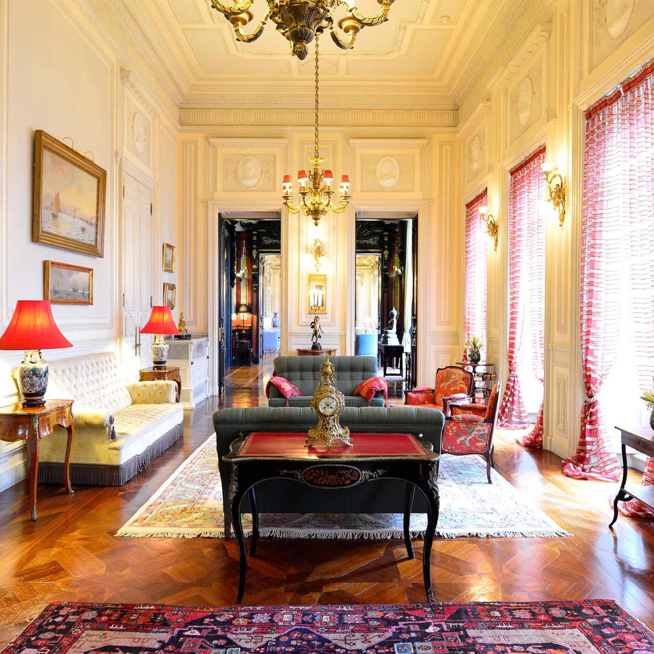 Salon du Pestana Palace Lisboa, avec canapés et fauteuils rembourrés, deux lustres dorés et murs en bois