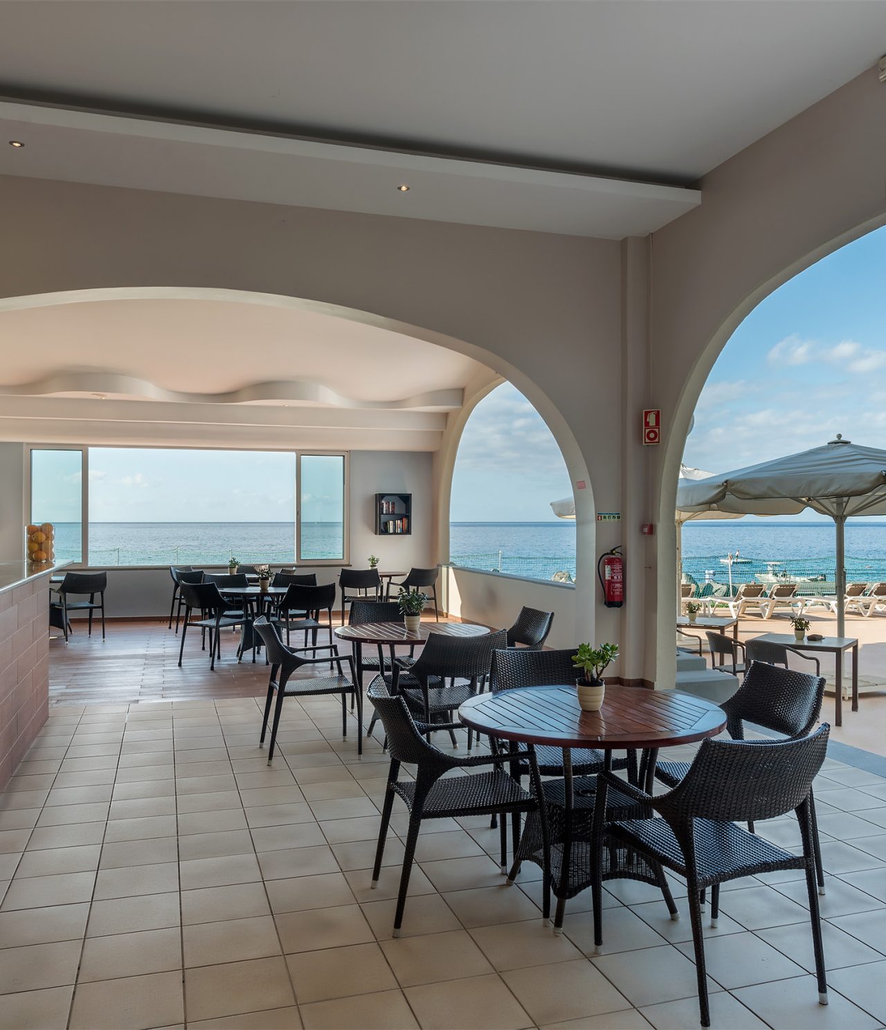 Le bar Atlântico de l’hôtel 5 étoiles à Madère a une terrasse couverte avec chaises, tables et vue sur la mer
