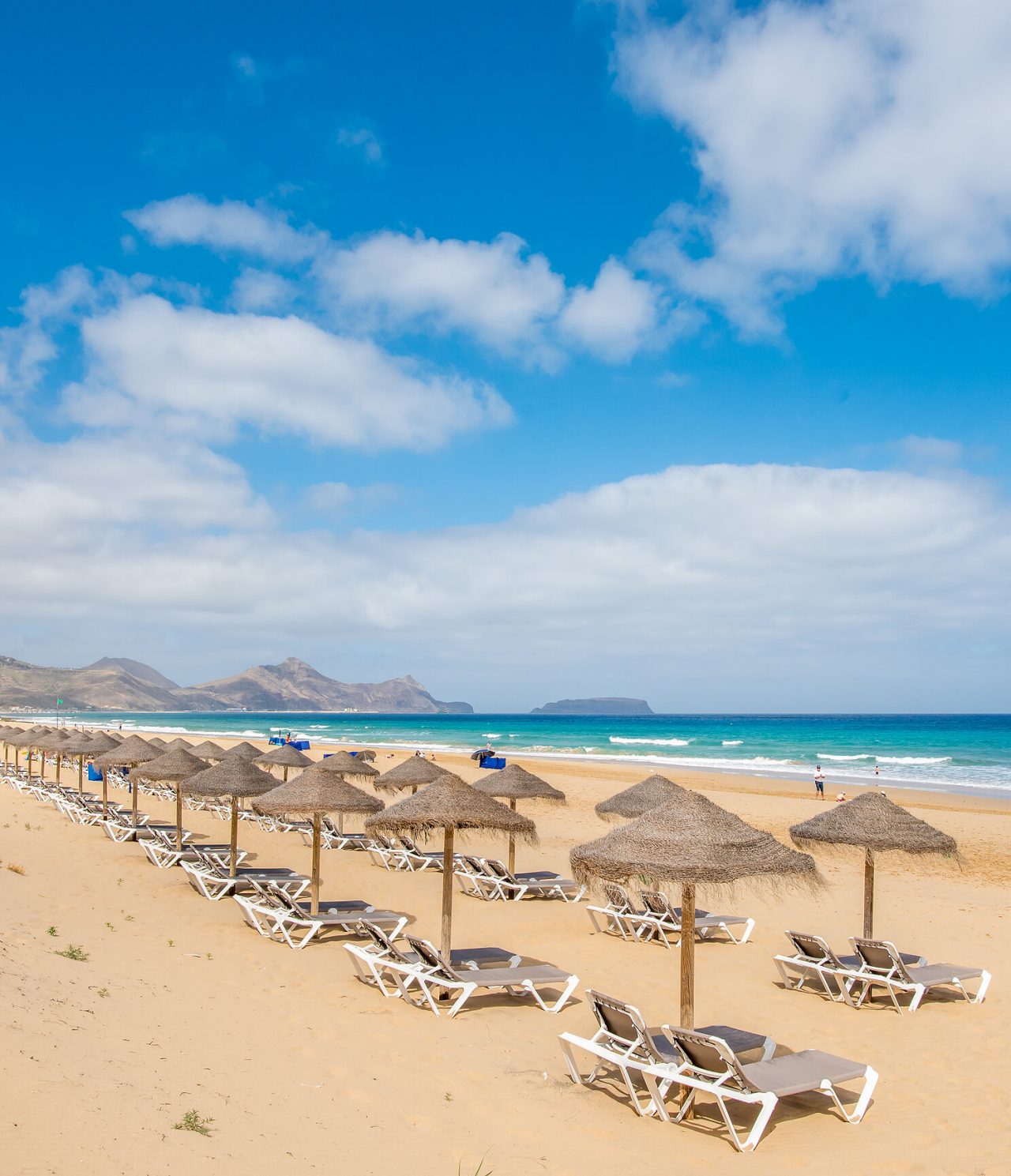 Plage de Porto Santo, avec plusieurs chaises longues et parasols, mer bleu turquoise et sable doré