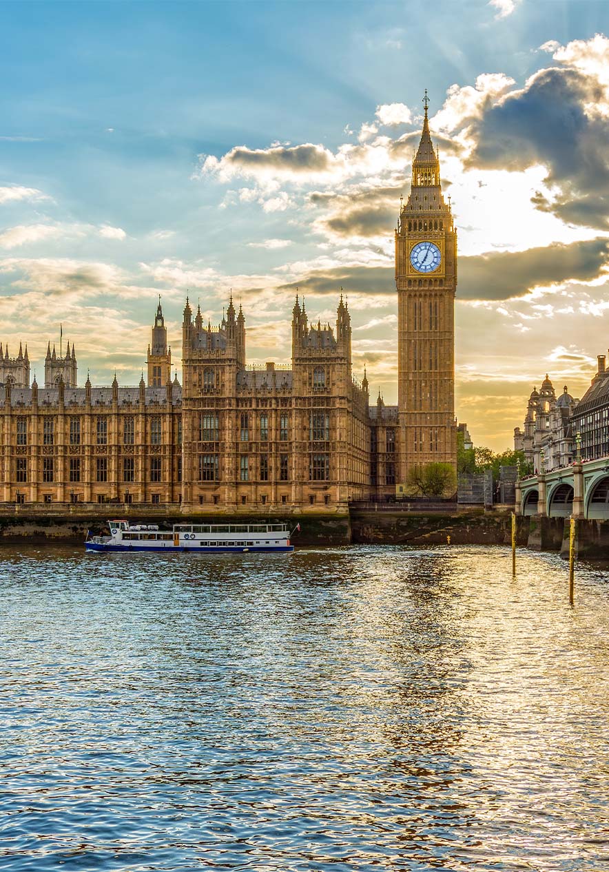 Vue sur Big Ben et le palais de Buckingham, avec le soleil se levant derrière les nuages, avec la rivière sur le côté