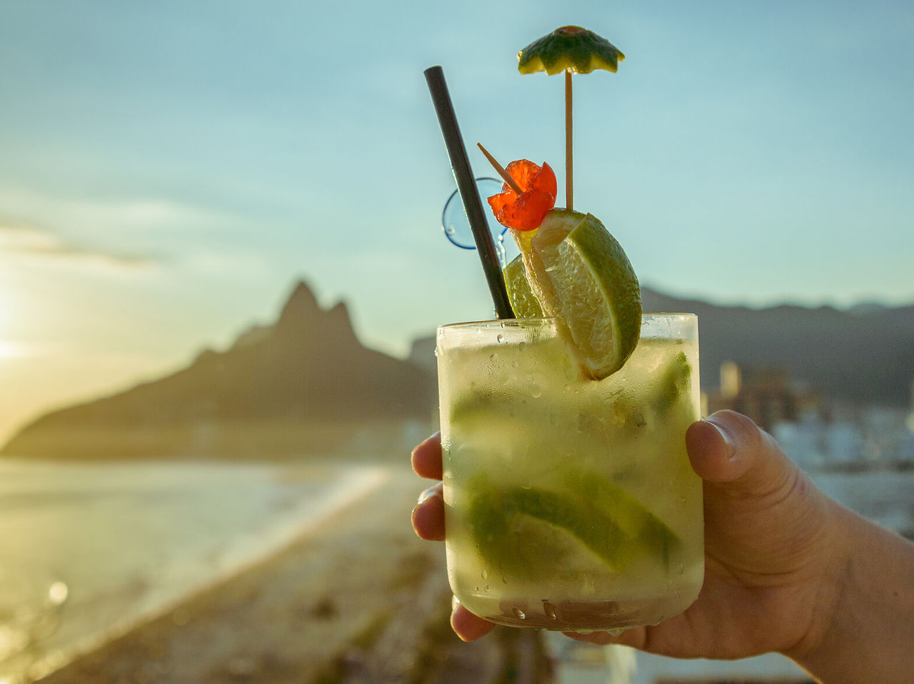 Caipirinha typique de Rio de Janeiro avec la plage d'Ipanema et la colline des Dois Irmãos en arrière-plan