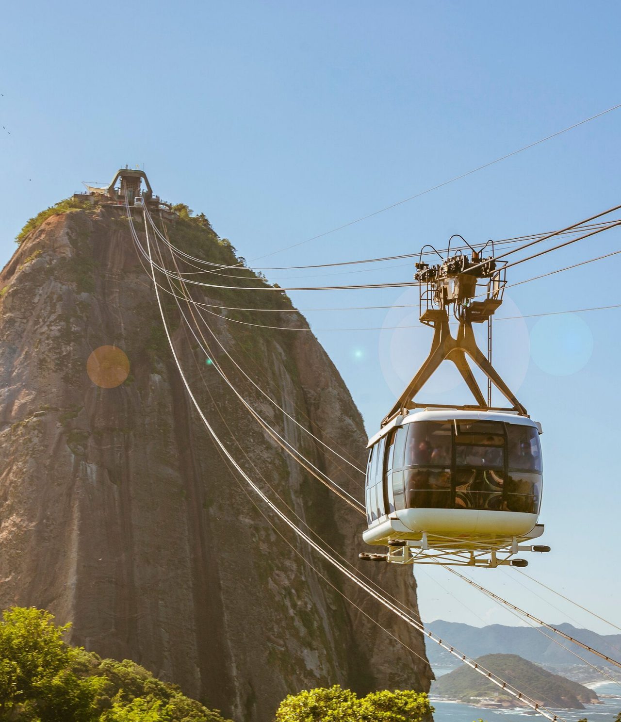 Vue du téléphérique à Rio de Janeiro, se dirigeant vers une haute colline, avec la mer en arrière-plan