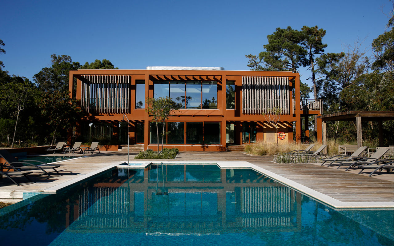 Villas avec piscine extérieure et chaises longues, dans un Eco Resort au Portugal, appartenant à la marque Pestana Residences