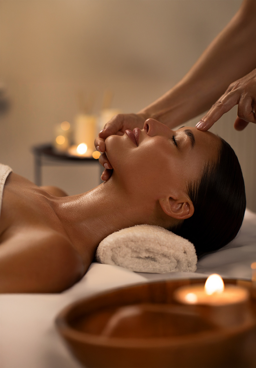 Un client reçoit un massage relaxant avec des bougies, créant une atmosphère paisible et chaleureuse au Pestana Magic Spa