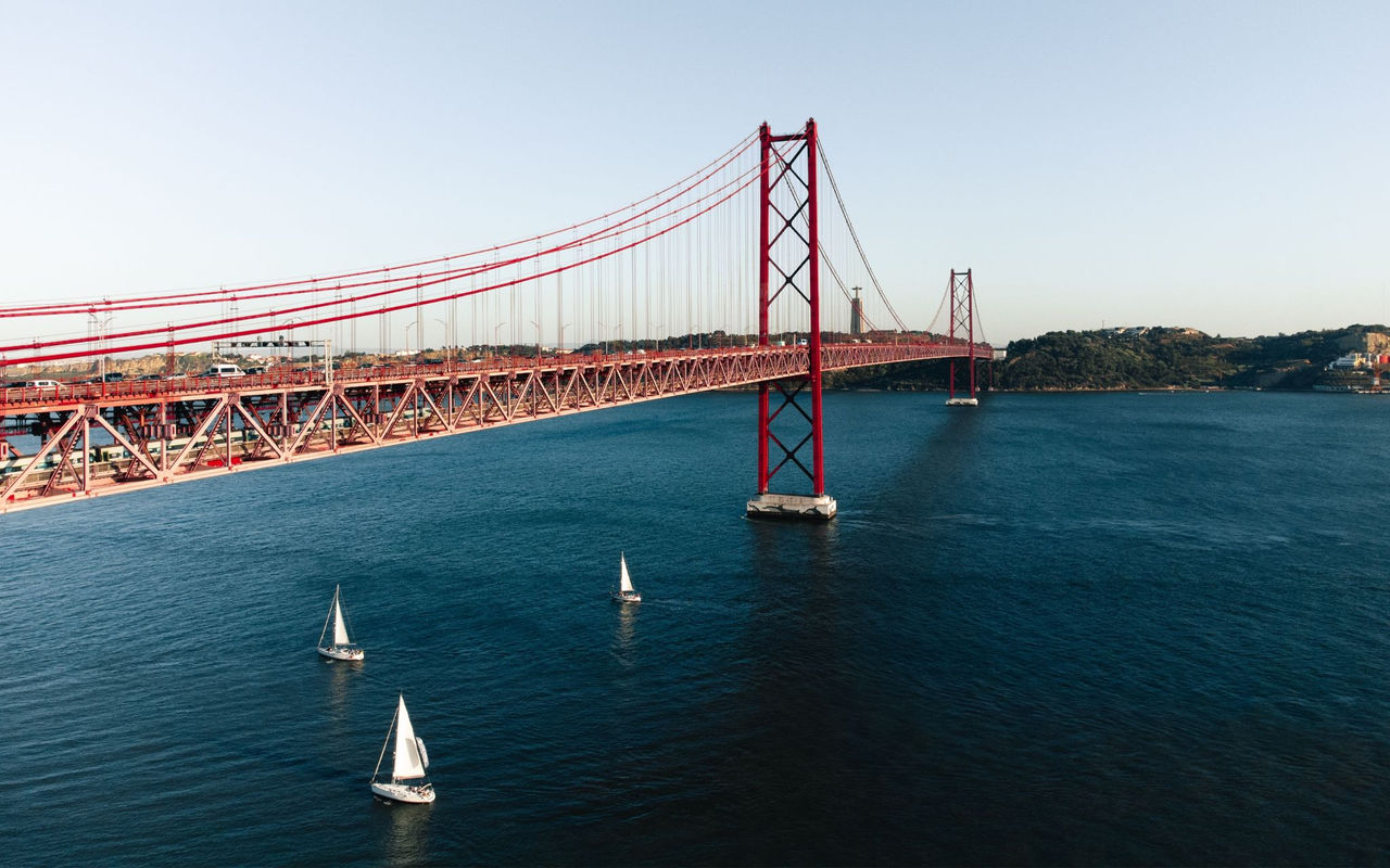 Panoramisch uitzicht op de stad Lissabon, met de rivier de Tejo, verschillende boten en de 25 Aprilbrug