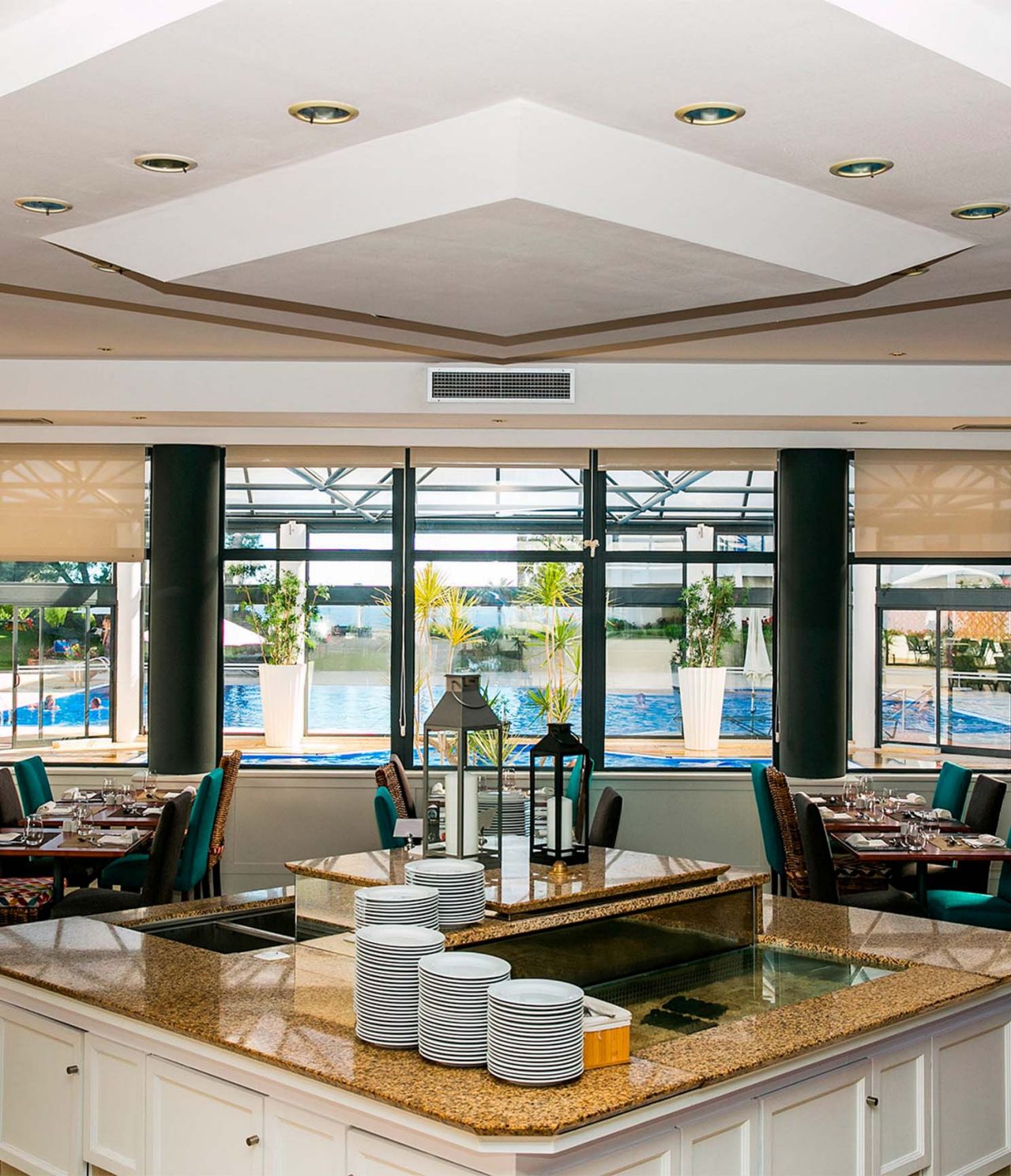 Het restaurant Oceano, van het 4-sterrenhotel in Cascais, heeft verschillende tafels en ramen met uitzicht op het zwembad