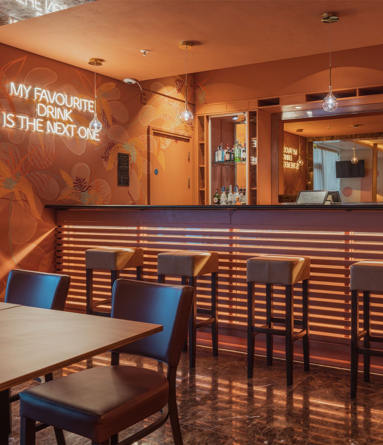 De bar The Bridge, van het 4-sterrenhotel in Londen, heeft een bar met hoge banken en LED-verlichting op de muur