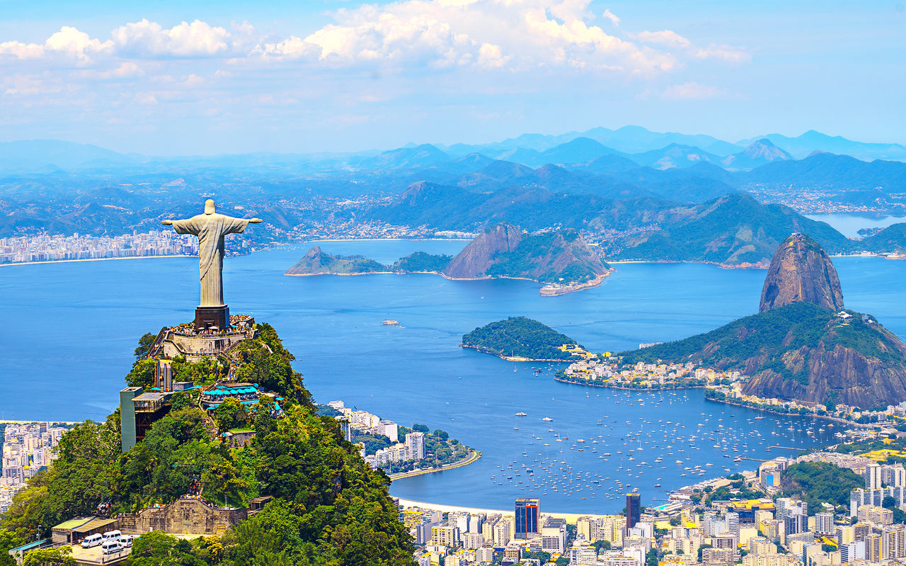 Iconisch standbeeld van Christus de Verlosser in Rio de Janeiro, met de stad, de oceaan en het strand op de achtergrond