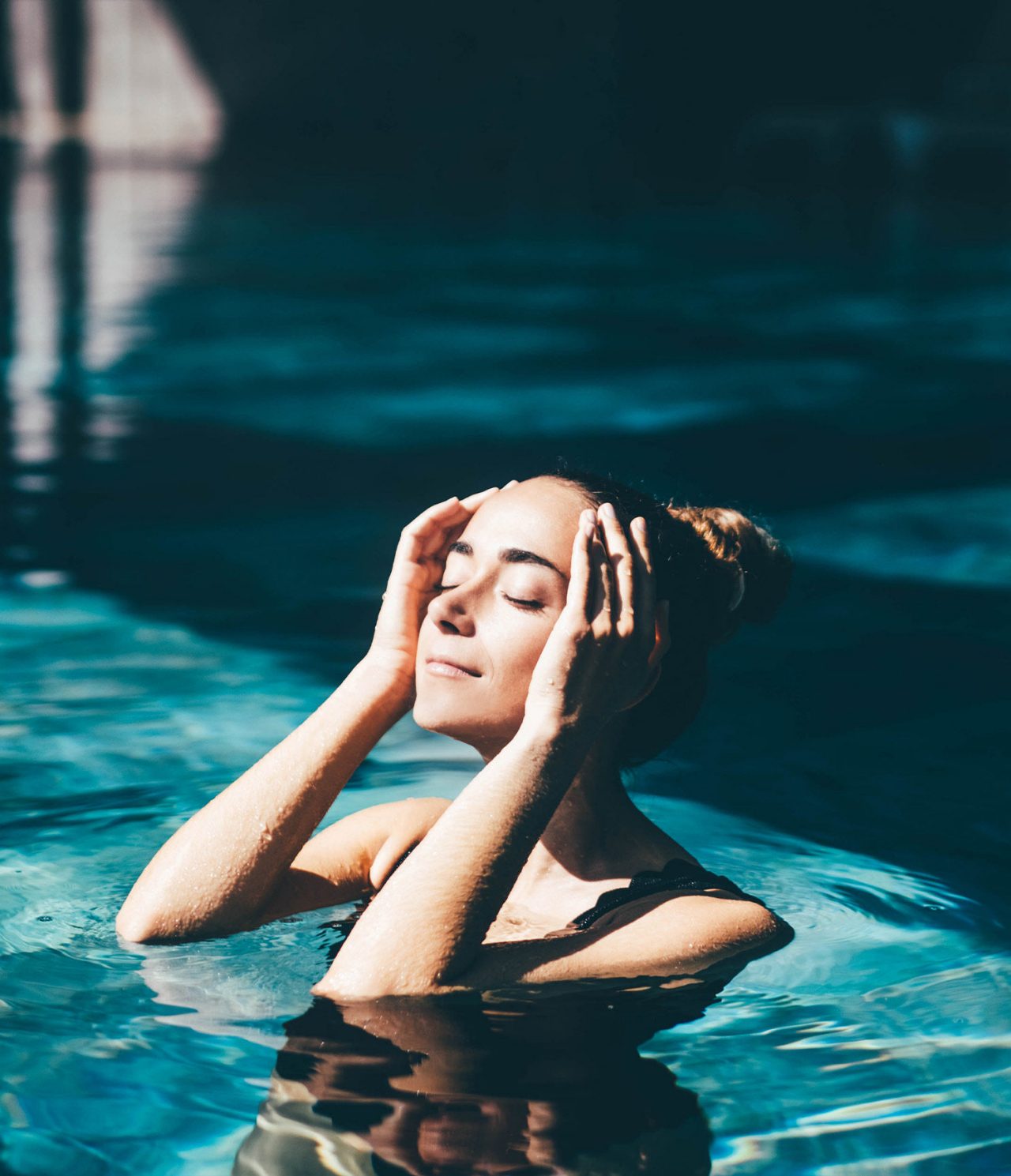 Een klant ontspant in het zwembad van Pestana Magic Spa onder de zon, genietend van een moment van ontspanning