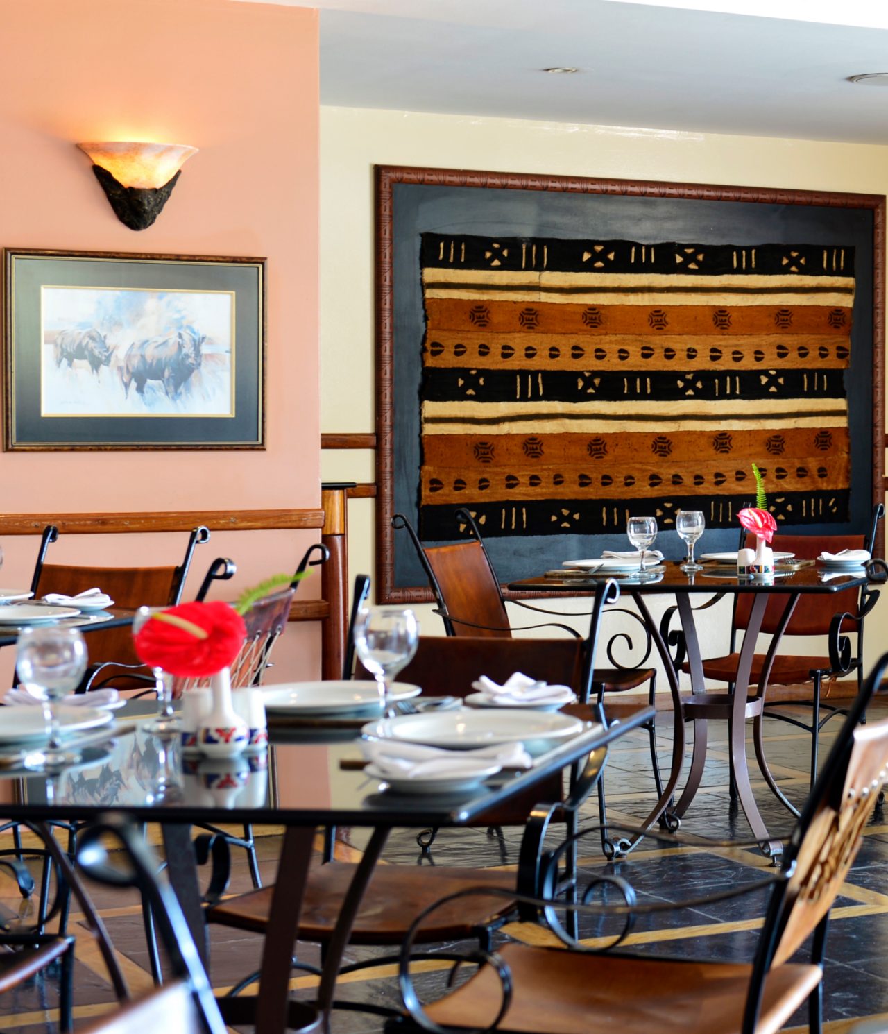 O restaurante Monomotapa, do Hotel 4 Estrelas em Maputo, tem várias mesas com uma flor vermelha e cadeiras