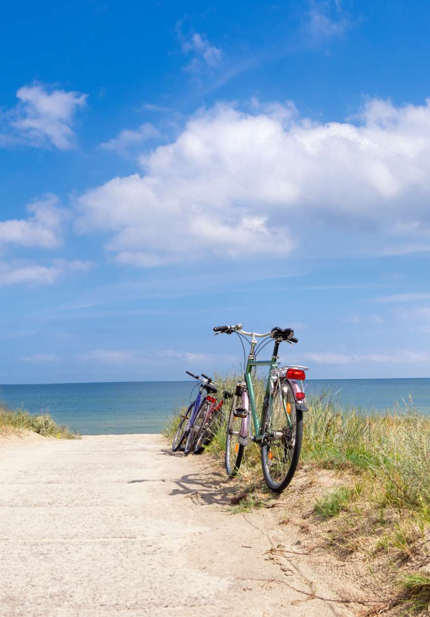Duas bicicletas paradas ao pé da estrada, junto à praia, depois de um longo passeio de bicicleta