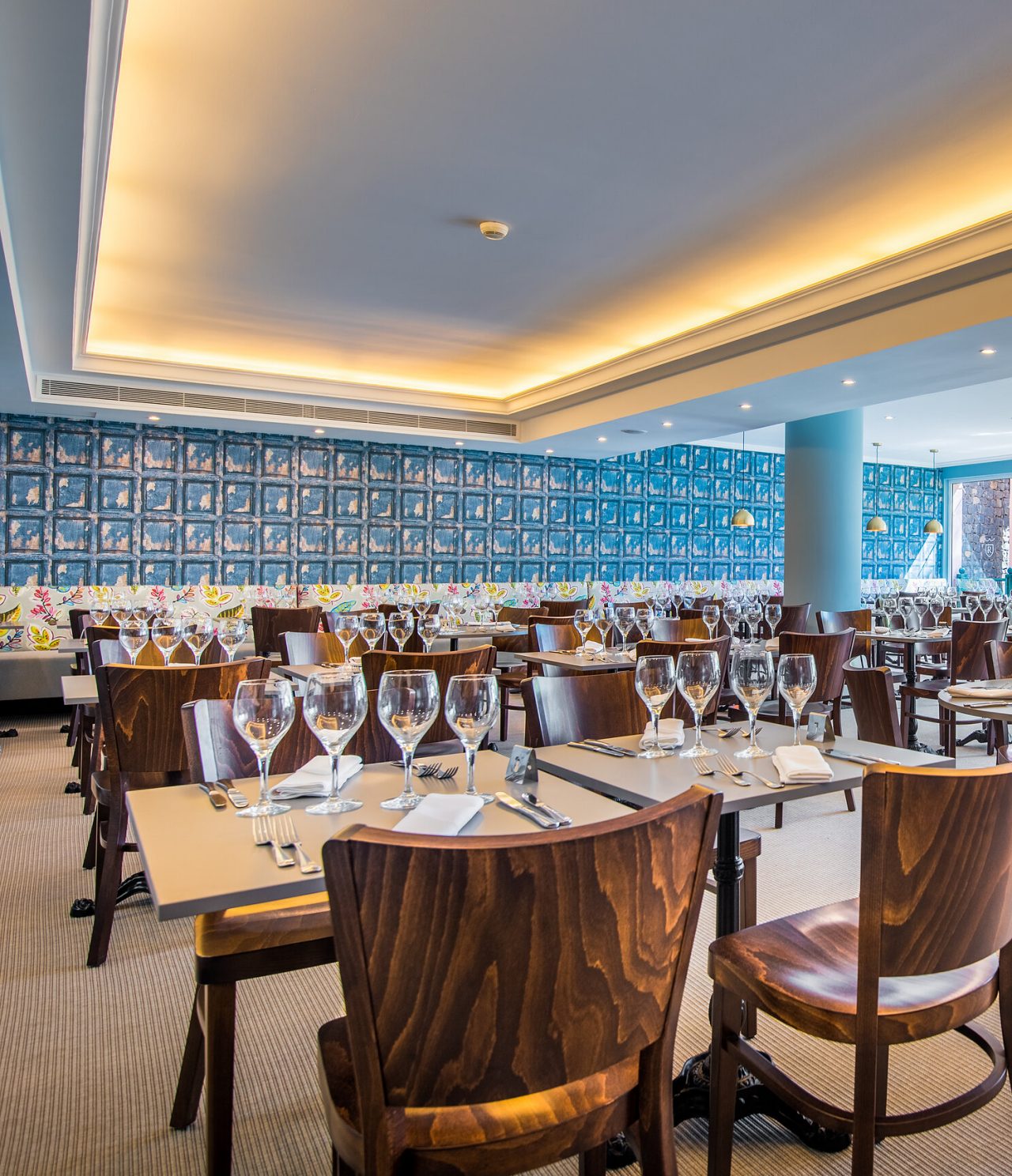 O restaurante Campo de Fiori, do Hotel 5 Estrelas no Funchal, tem um espaço amplo com paredes coloridas, e mesas e cadeiras