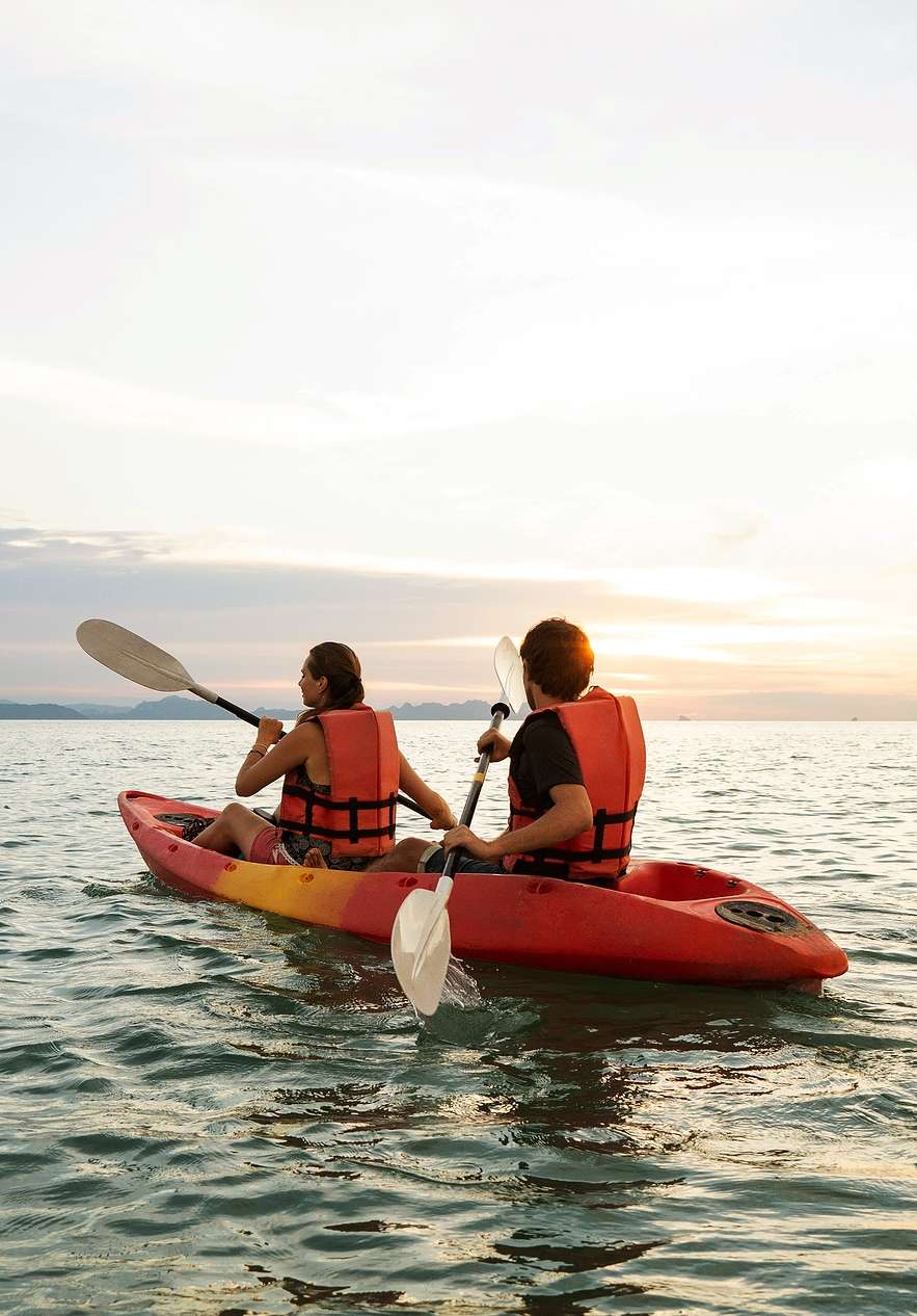 Two people paddling in a kayak on the calm sea of Comporta