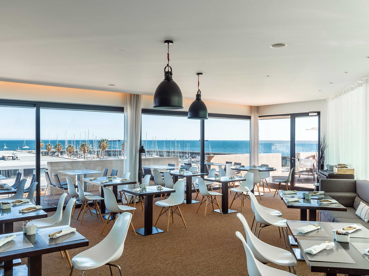 Restaurant Maris Stella at the 5-Star Hotel in Cascais has several tables, chairs and a view of the Cascais marina