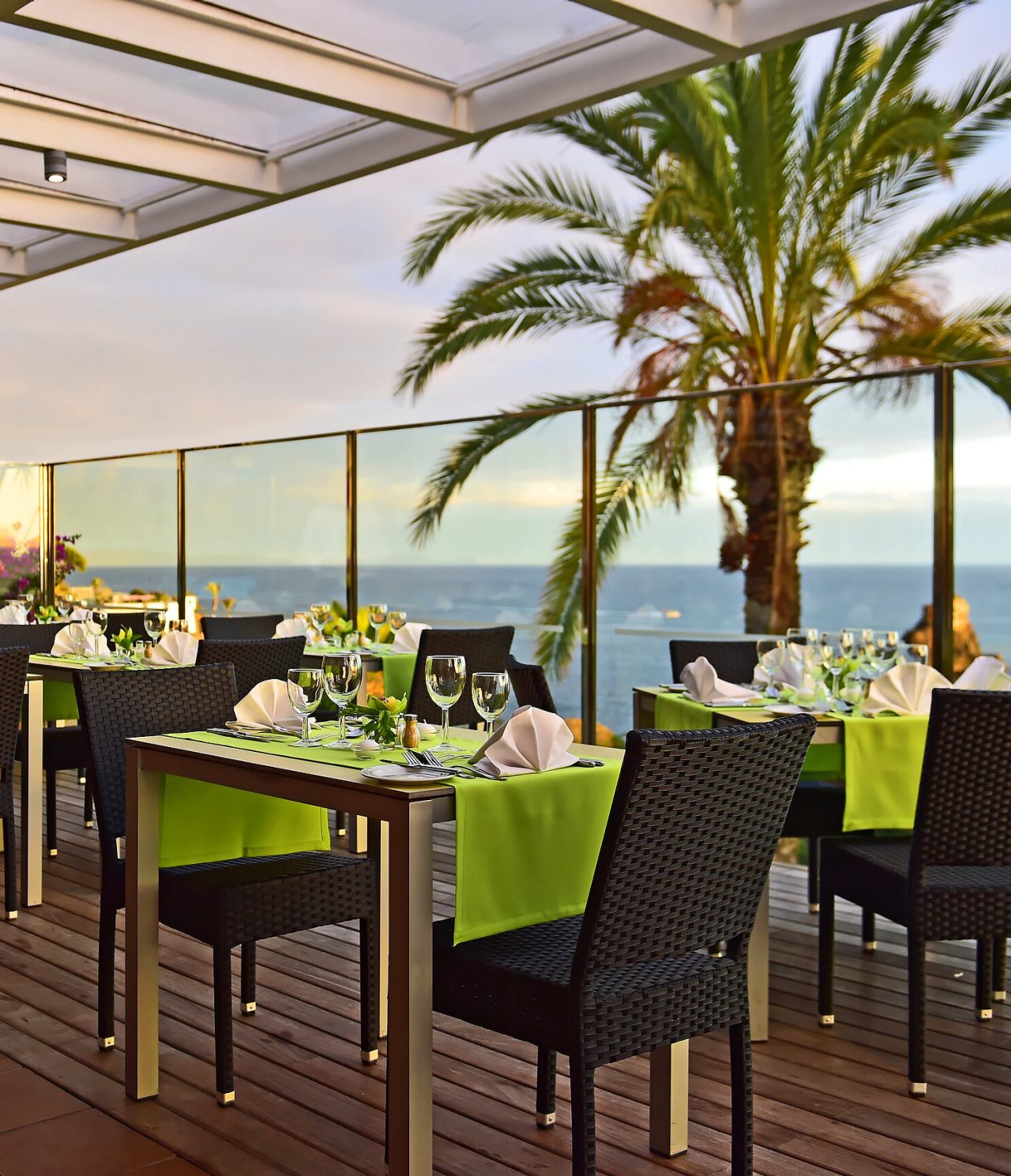 The Deck Restaurant, at a 4-Star Hotel by the Sea in Funchal, has green tablecloths with sea views